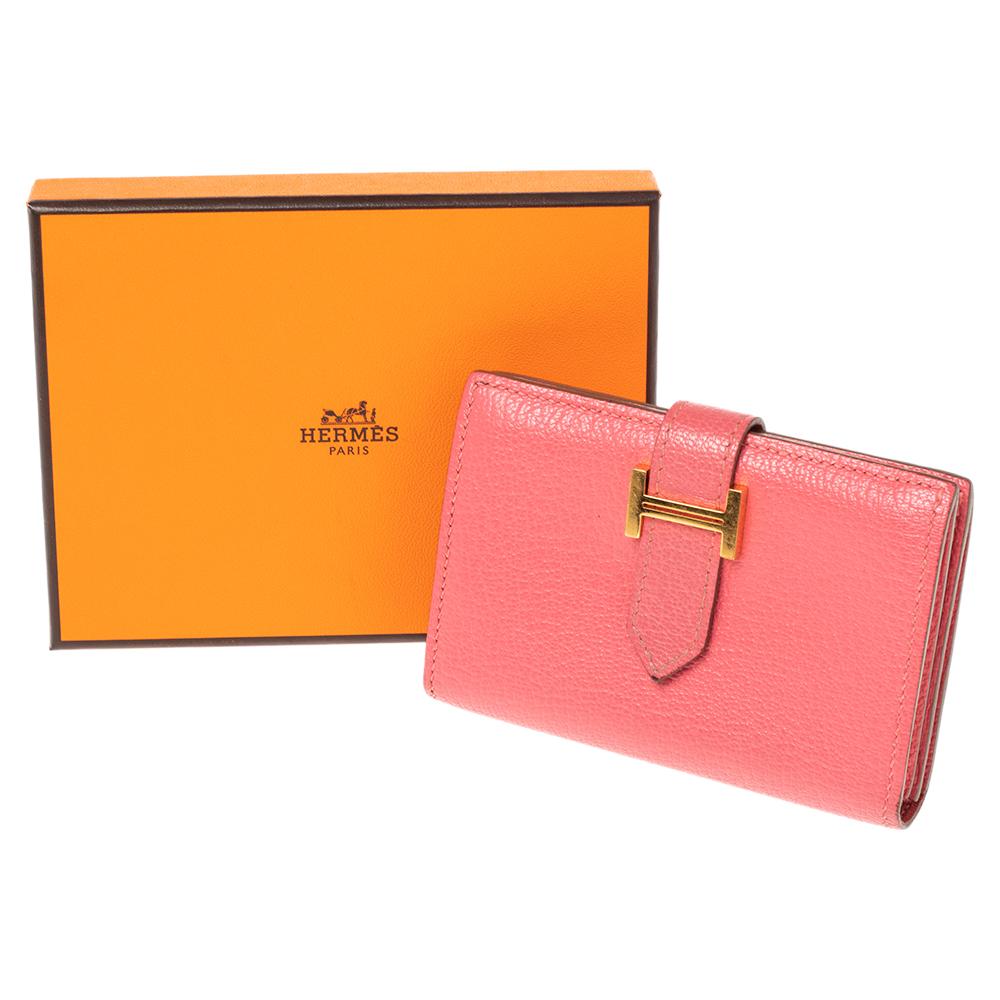 Hermes yet again charms us with this stunner of a creation that looks quite chic and stylish! This pretty pink Bearn cardholder is crafted from leather and features a front tuck-in strap closure with a gold-tone 'H' buckle and opens to a