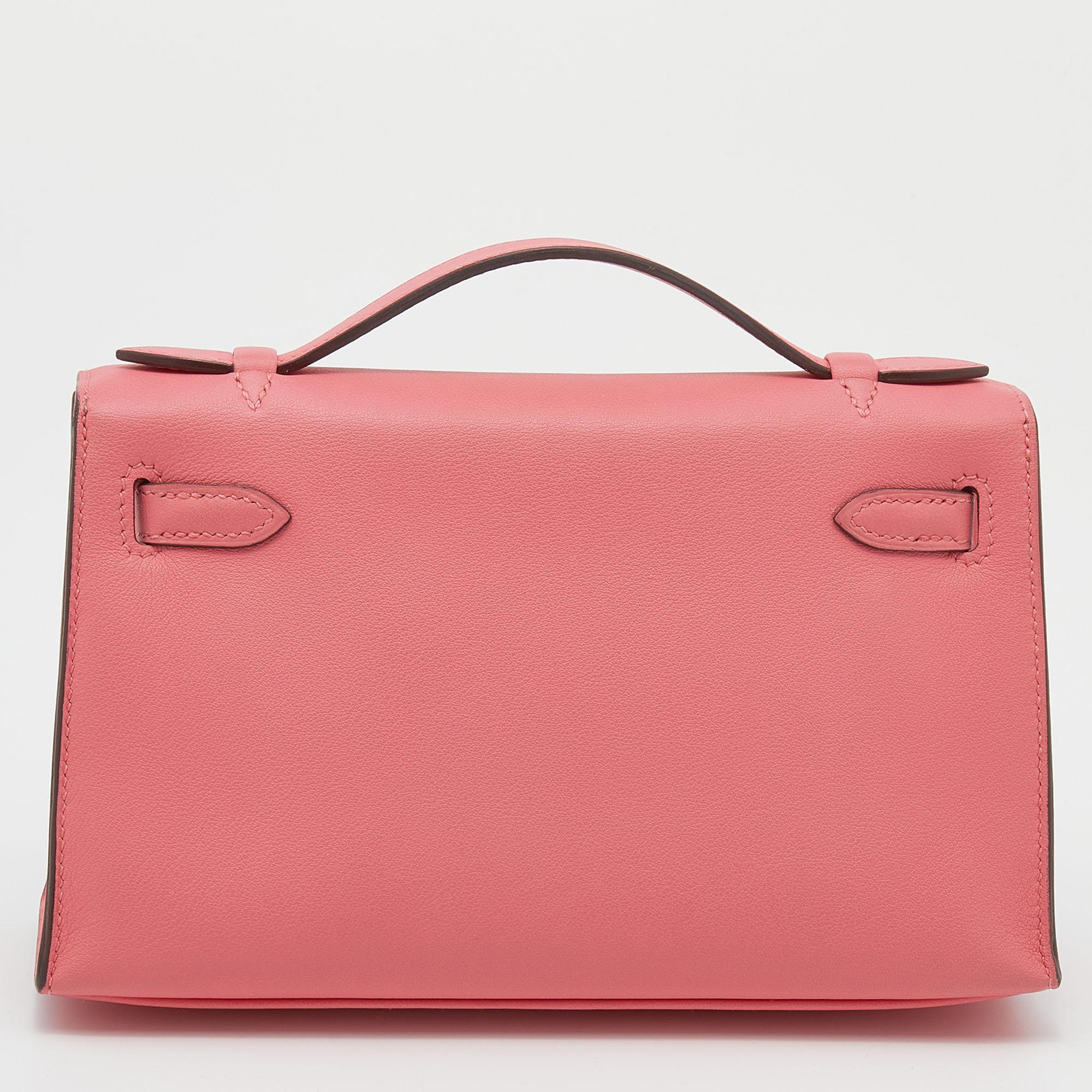 This Kelly Pochette is a delighting find. Named and inspired by the world-famous Kelly bag, this wondrous work of art is presented in Rose Lipstick Swift leather and secured by the iconic Kelly lock. Its flap opens to reveal a well-sized leather