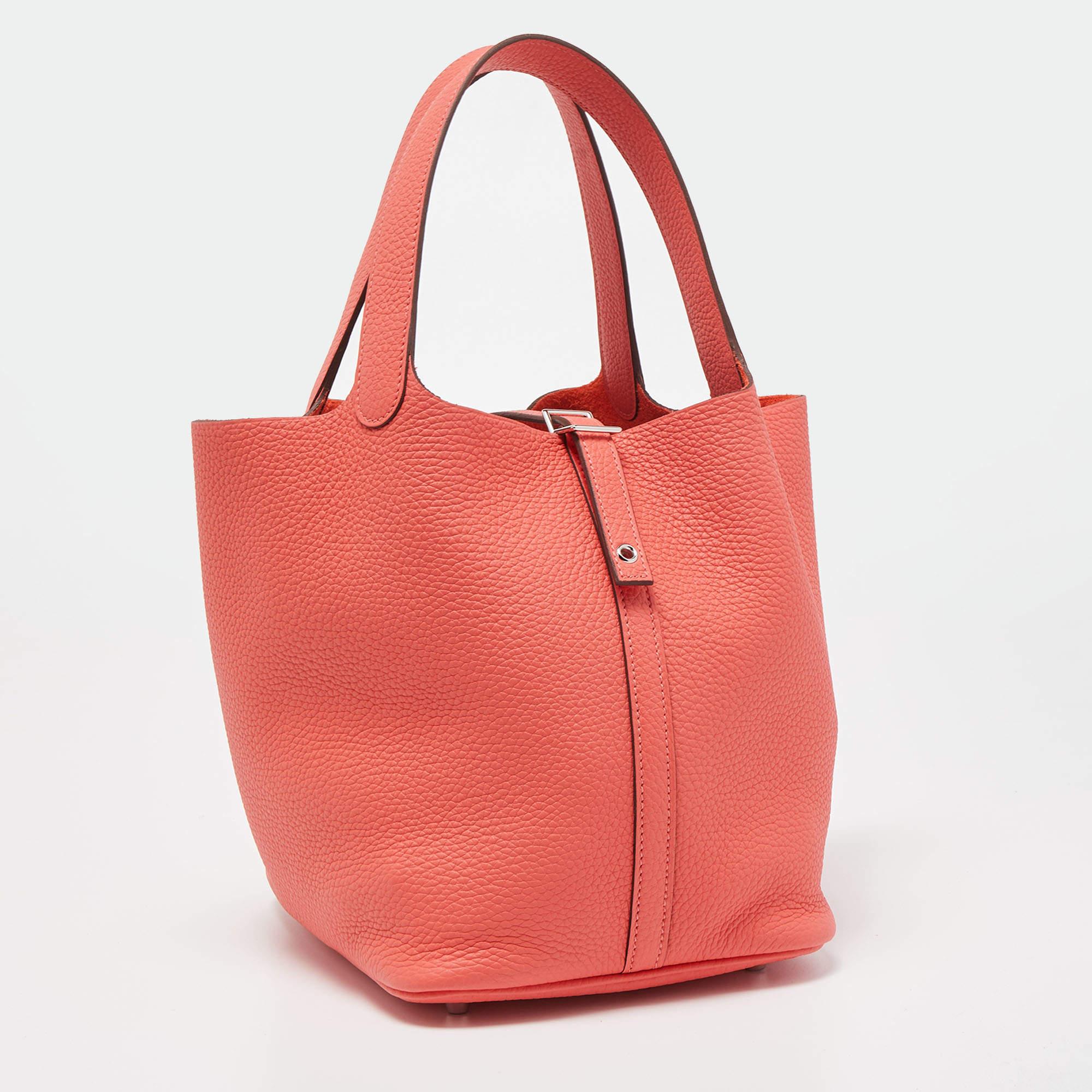 The Hermès Picotin Lock 22 bag is an exquisite accessory, showcasing impeccable craftsmanship and luxury. Crafted from rich Taurillon Clemence leather in a vibrant Rose Texas hue, it features a distinctive basket shape with a secure Picotin Lock