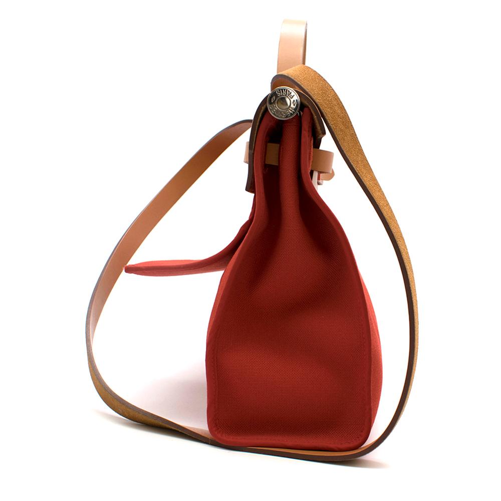 Hermes Herbag in red canvas and beige leather with a shoulder strap and top handles. 

-Age A - 2017
- 31 CM
- Outside zip pocket and palladium plated Clou de Selle closure
- Clutch bag included 

It comes with the Red canvas Herbag zip with the