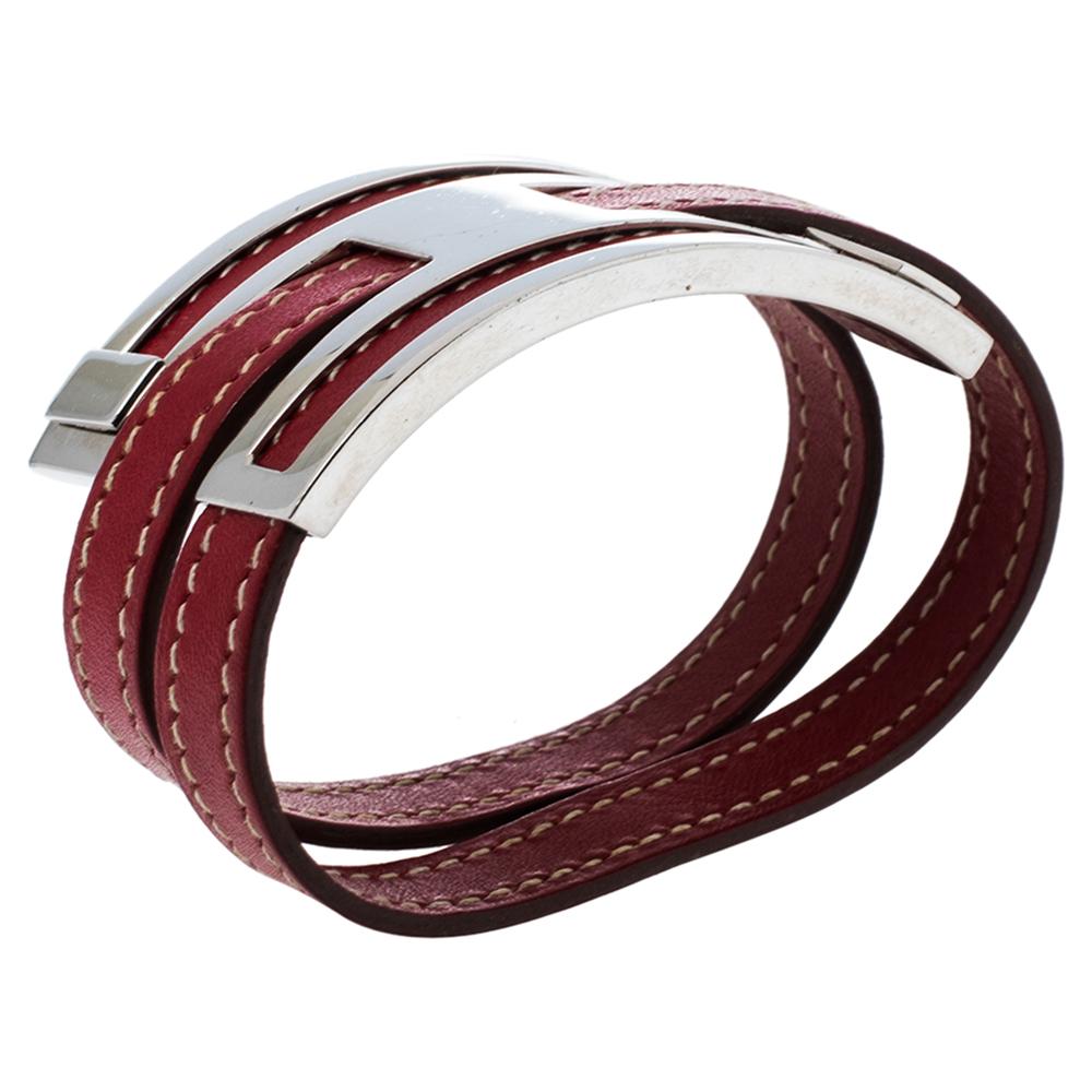 Simplicity and utmost sophistication take center stage in this Pousse Pousse bracelet from Hermès. It comes finely crafted from leather in a lovely red shade and adorned with an 'H' shaped buckle in palladium-plated metal. The neat stitching and