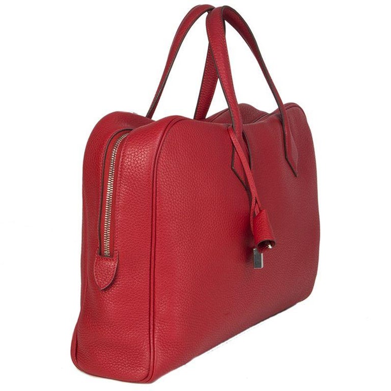 Hermes 'Victoria II Porte-Documents' business bag in Rouge Garance (true red) Taurillon Clemence leather. Closes with a two-way zipper. Lined in canvas with three open pockets against the front and a laptop pocket against the back. Has been carried
