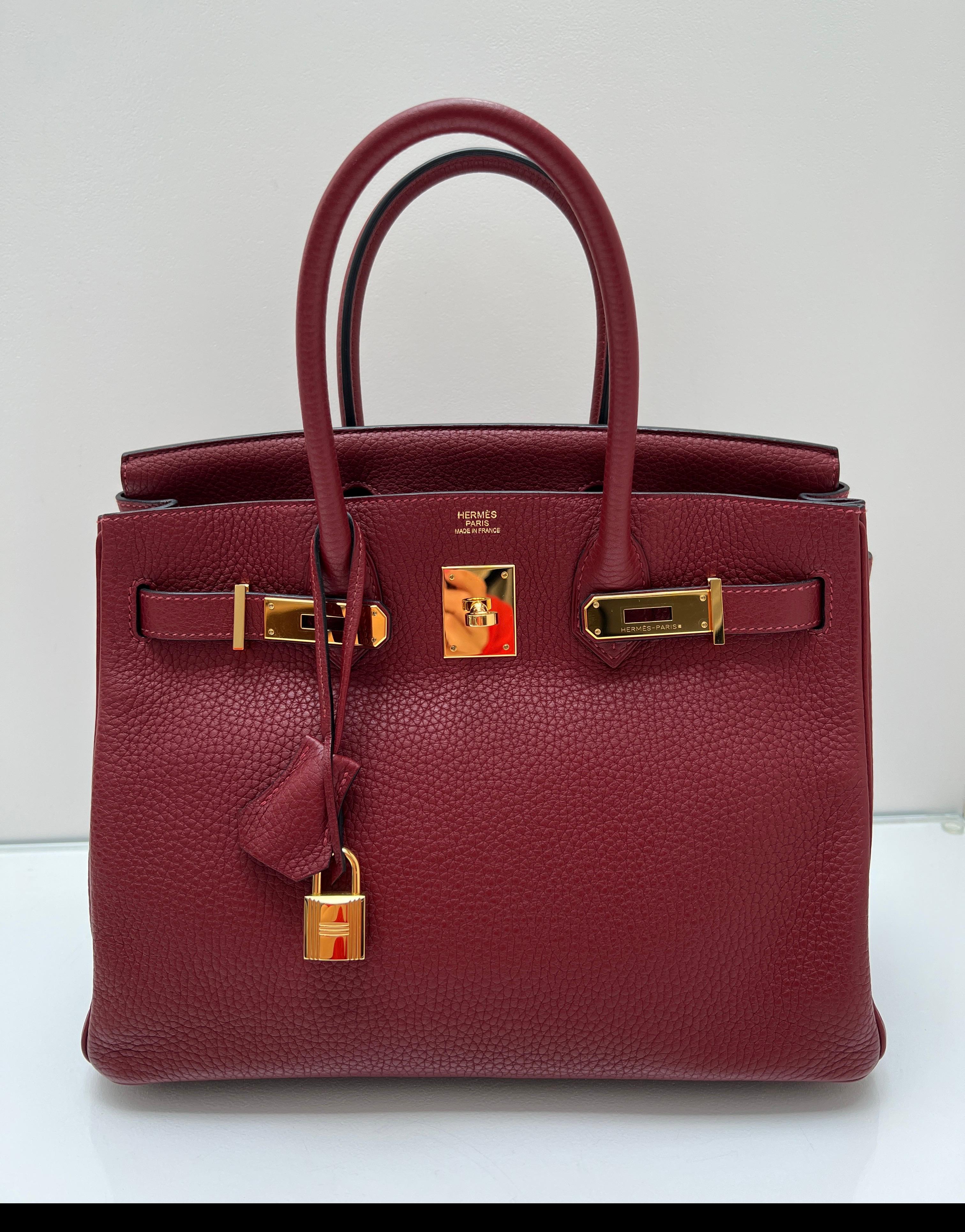 Hermes Rouge H Birkin 30 Tasche. Die meistgesuchte Farbe des Jahres. Wunderschöne burgunderrote Farbe mit goldenen Beschlägen. Innen sauber. Ausgezeichneter Zustand. Sieht aus wie neu. Clemence Leder. Inklusive Clochette, Schloss, Schlüssel und
