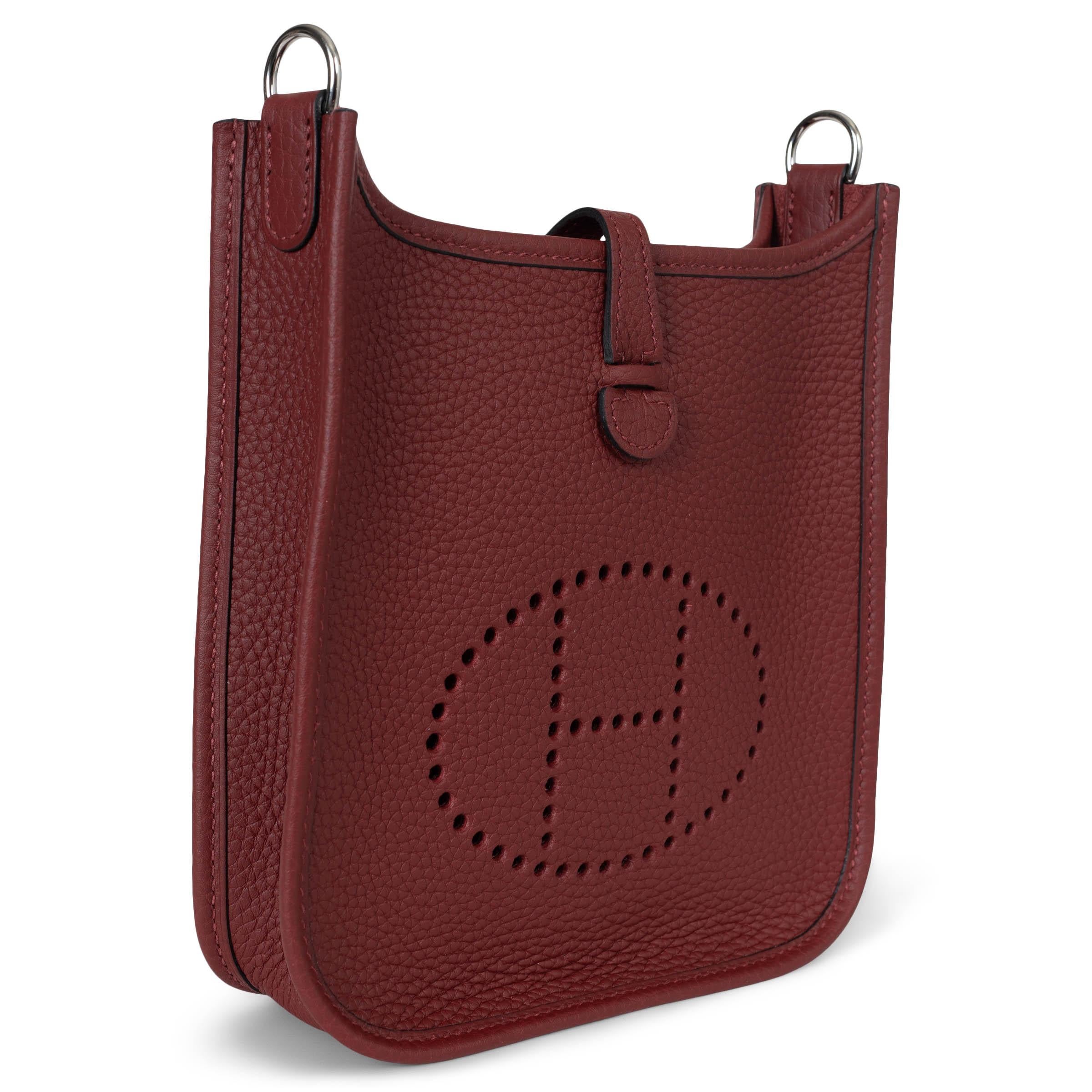 This 100% authentic Hermès Evelyne 16 TPM Crossbody Bag in Rouge H (burgundy) Taurillon Clemence leather is a timeless addition to any collection. Featuring the iconic perforated 