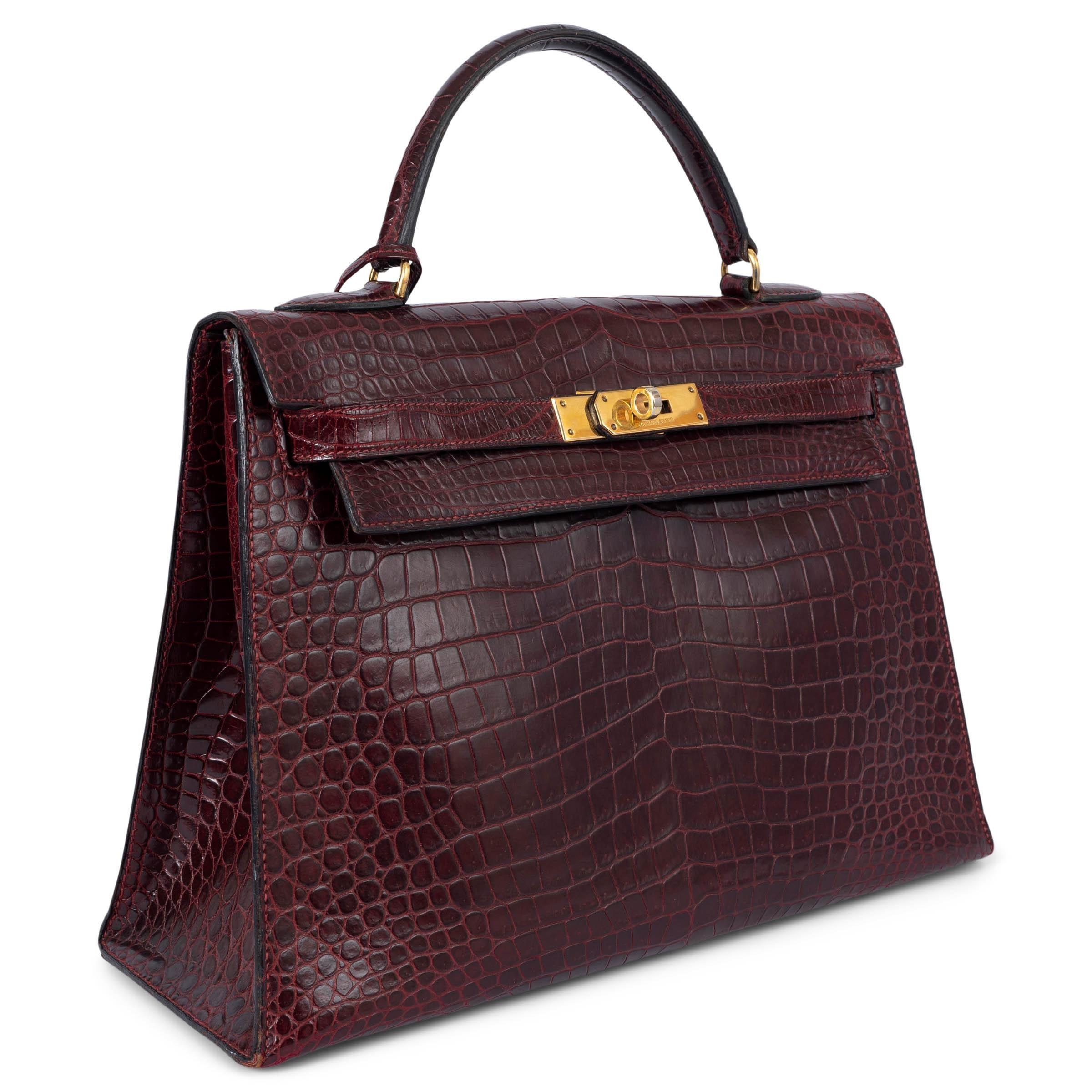 100% authentic Hermès Kelly 32 Sellier bag in Rouge H Matte Prorosus Crocodile with gold-tone hardware. Lined in burgundy Cherve (goat skin) with two open pockets against the front and a zipper pocket against the back. Has been carried and shows