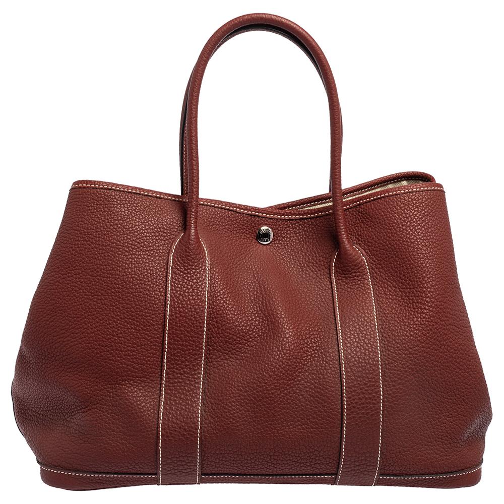 Look every part the royal diva you are by swinging this exquisite Garden Party tote from Hermes. This beauty has been meticulously crafted from leather and equipped with two top handles for you to parade it. Its canvas and leather interiors are