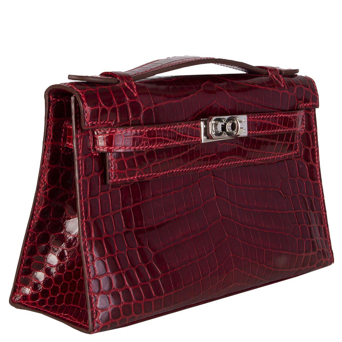Hermès 'Kelly Pochette' in Roughe H (burgundy) shiny niloticus crocodile. Lined in Chèvre (goat skin) with an open pocket against the back. Has been carried and is in excellent condition. Comes with dust bag. 

Height 14cm (5.5in)
Width 22cm