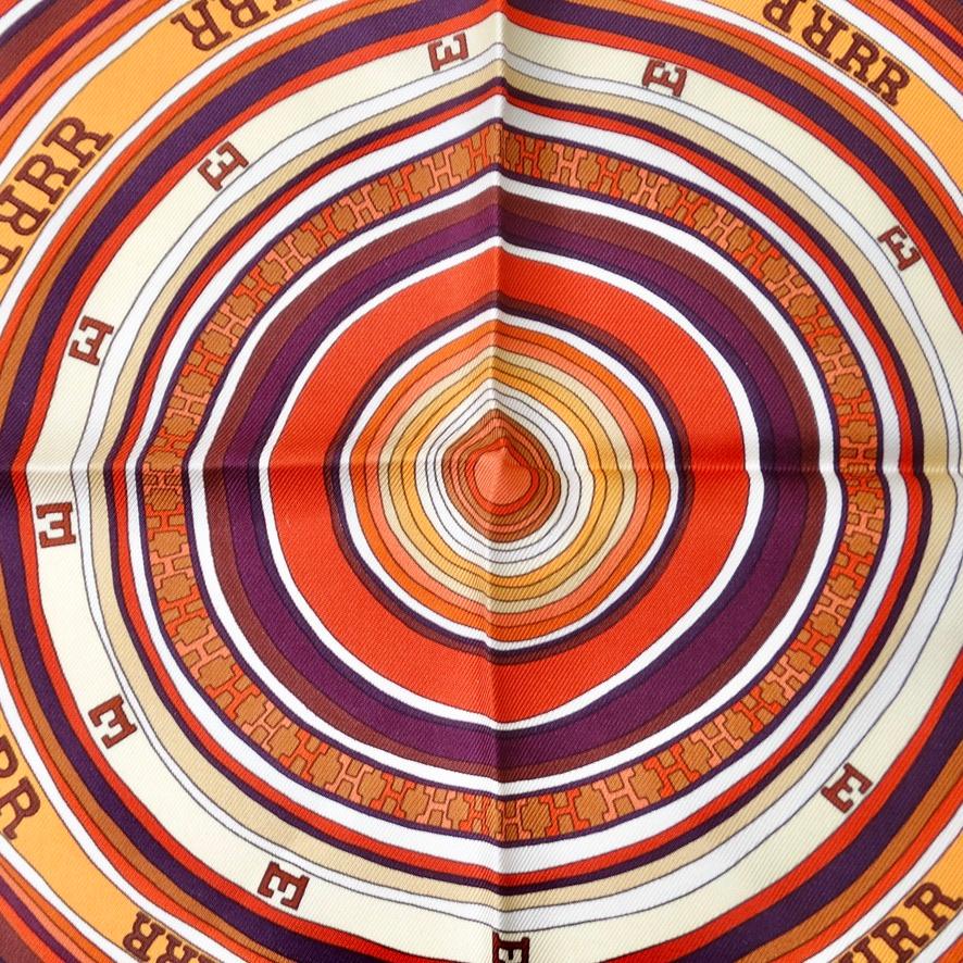 Do not miss out on this breath taking Hermes silk scarf circa 2004! Designed by Claudia Stuhlhofer-Mayr, vibrant orange silk features a circular pattern and arrangement of letters which translates to 'state of confusion' and Tohu Bohu's letters