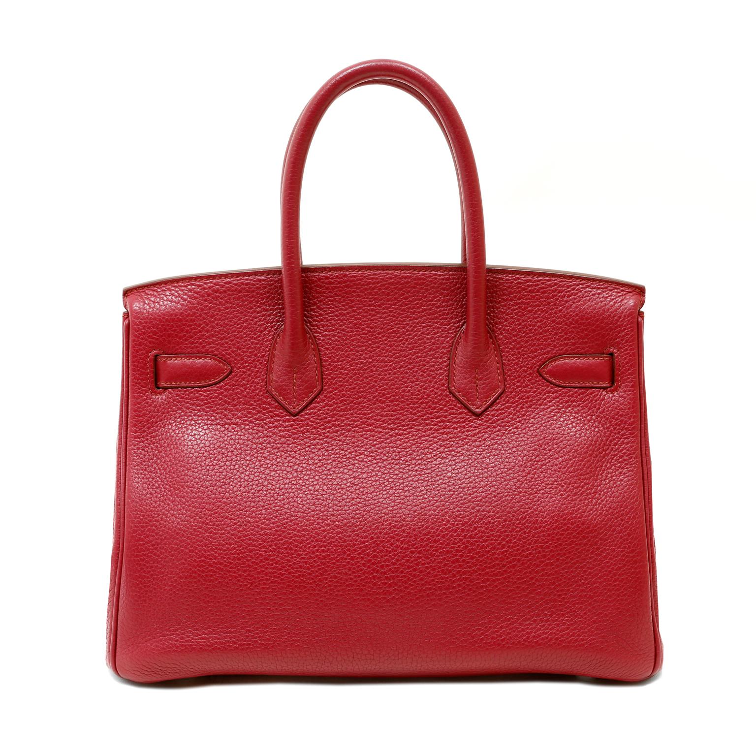 This authentic Hermès Ruby Red Togo 30 cm Birkin is in excellent condition. The handstitched Birkin is harder than ever to acquire, especially in the coveted 30 cm silhouette.
Lipstick red Togo leather is textured and soft to the hand.  It is the