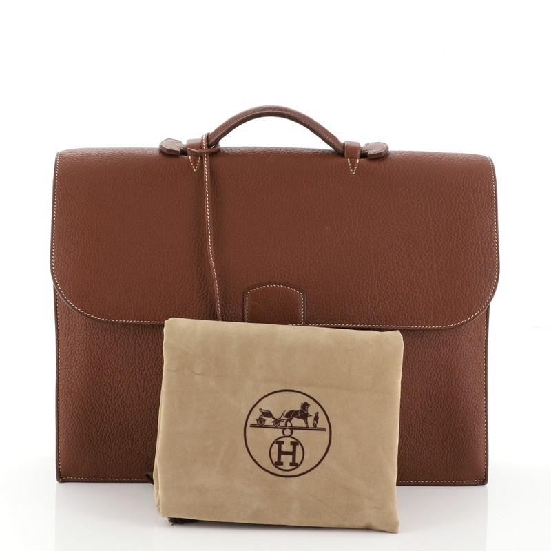 This Hermes Sac a Depeches Bag Buffalo 41, crafted from Fauve brown Buffalo leather, features flat top handle, accordion side gussets, and palladium hardware. Its flip lock closure opens to a Fauve brown raw leather interior with two main