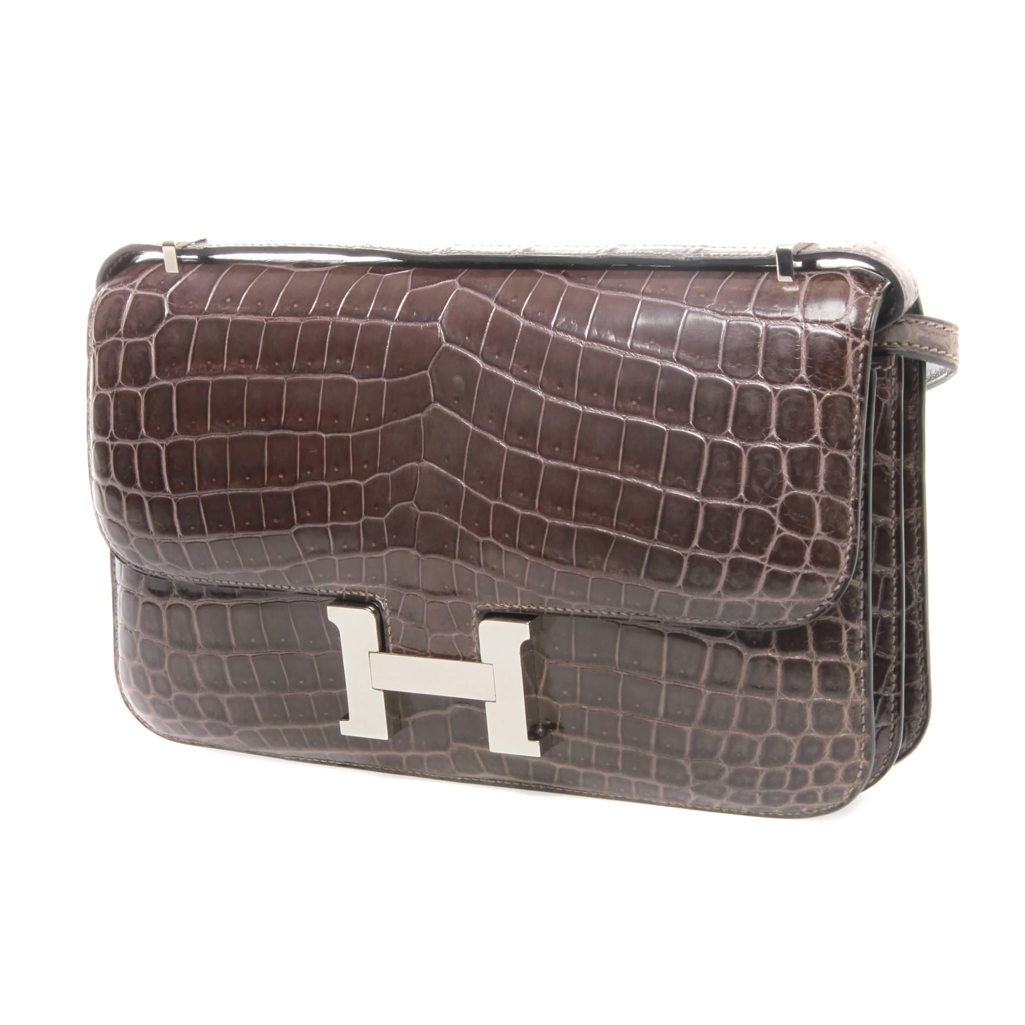 Hermès 25cm Brown Crocodile Constance Elan Bag

A Collectable-vintage 25cm shiny Niloticus Crocodile Constance Elan bag with large iconic H clasp palladium hardware.
Featuring shoulder strap converts to cross body 122.2cm x L:53.7cm drop, flap top