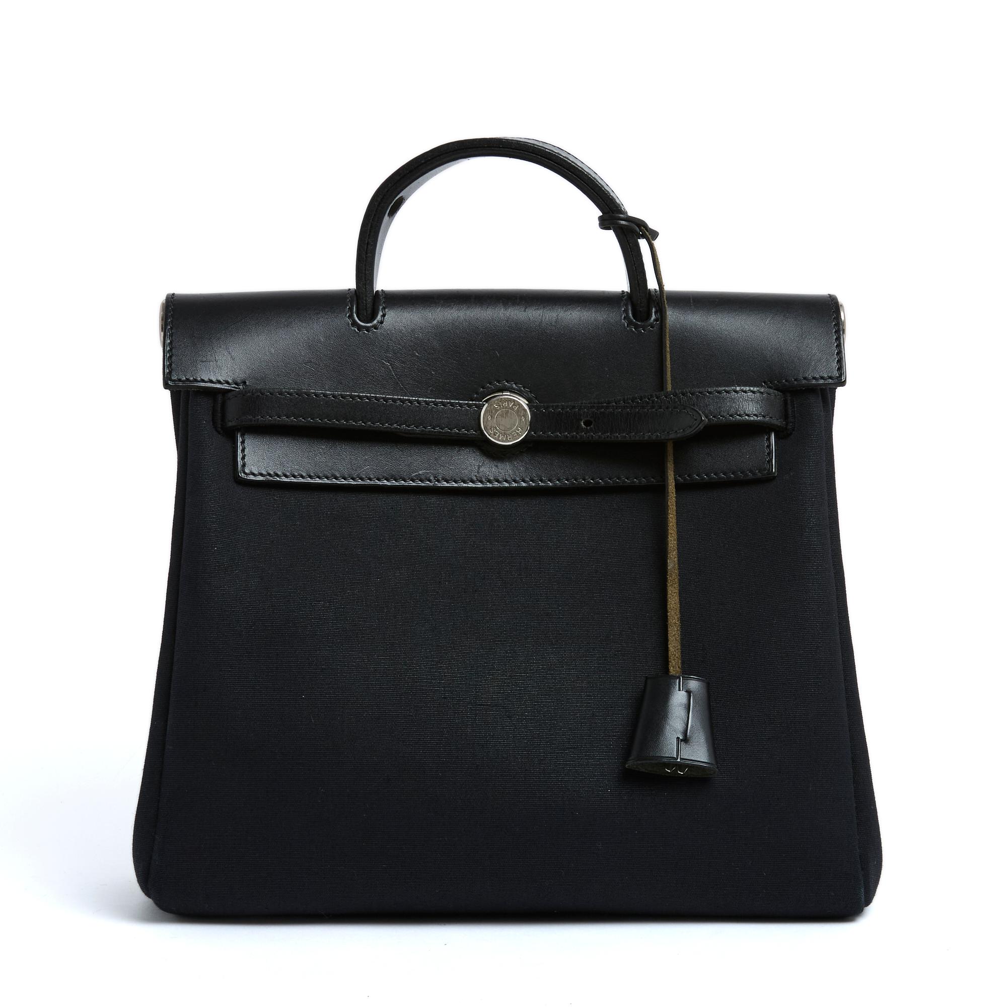 Hermès Herbag model bag in 2 versions to carry by hand or as a backpack, composed of a small Kelly bag format pouch in black canvas and a larger Kelly Ado bag format, mobile part in leather with handle, flap, straps, zipper and bell, Kelly padlock