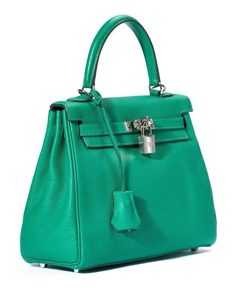 Borsa firmata Hermès, modello Sac Kelly nella misura 25. Realizzata in pelle Courchevel verde con hardware argento.  Dotata di una patta con chiusura ad incastro con fascia orizzontale, lucchetto e clochette con chiavi. Munita di un manico centrale