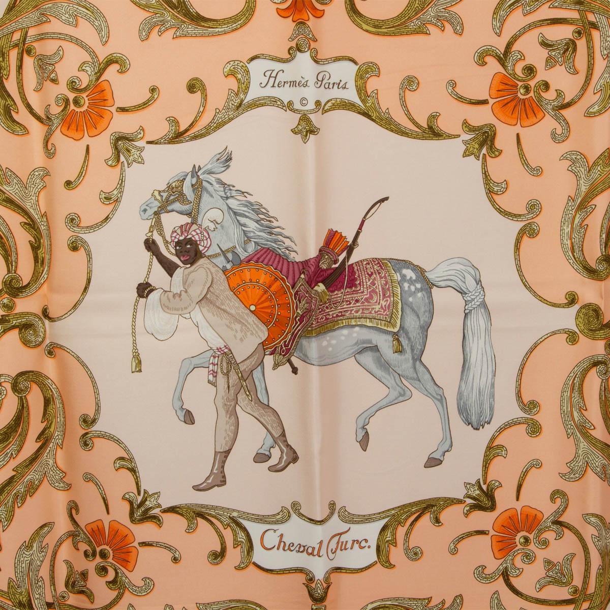 100% authentique écharpe Hermès 'Cheval Turc 90' par Christiane Vauzelles en sergé de soie rose saumon (100%) avec bordure orange, centre blanc et détails en vert kaki et gris clair. A été porté et est en excellent état.

Publié en