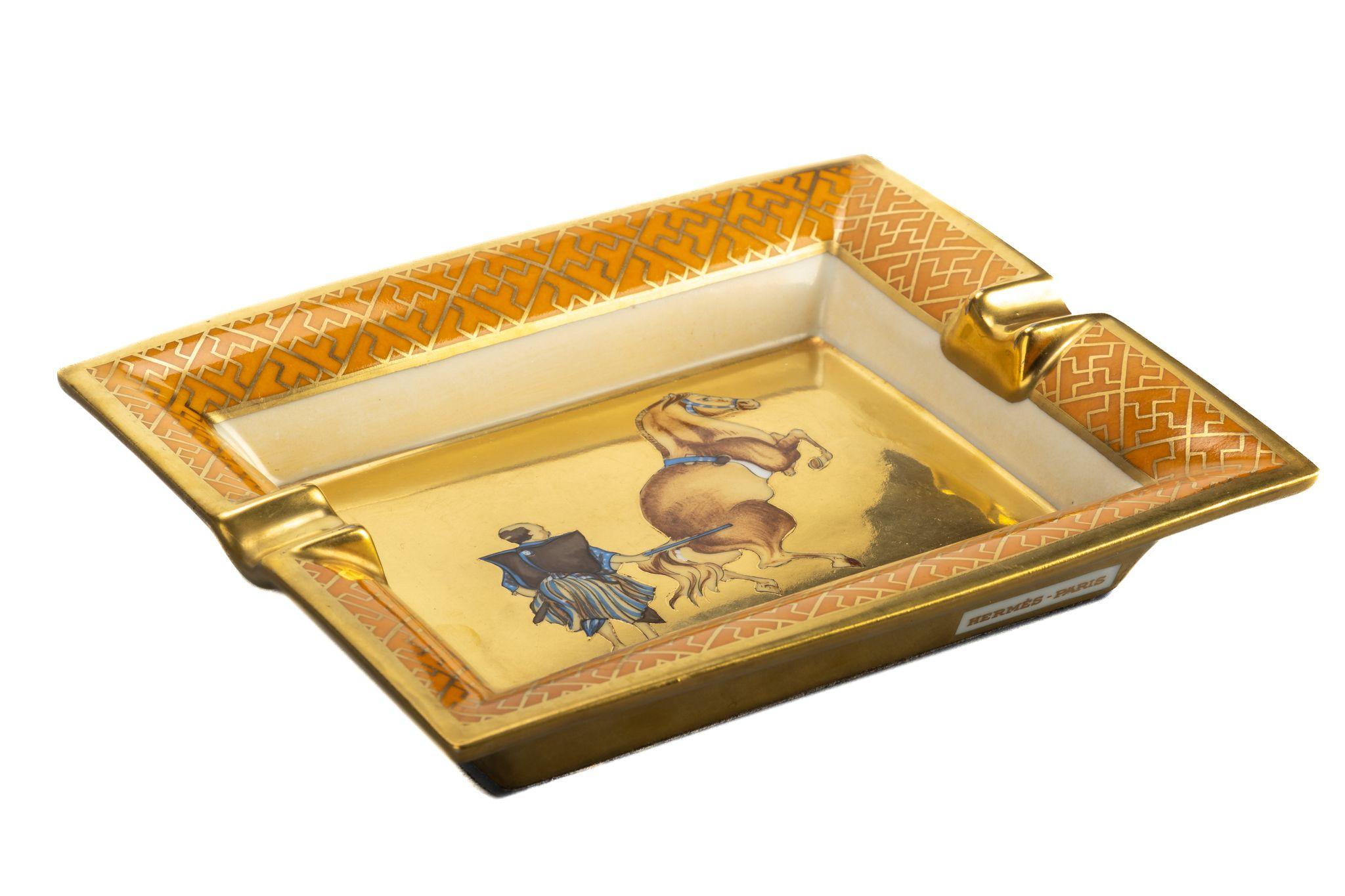 Hermes signature ashtray with samurai with horse design in yellow and gold. Suede stamped bottom. Minor wear on it. Made in France. Comes with original box.