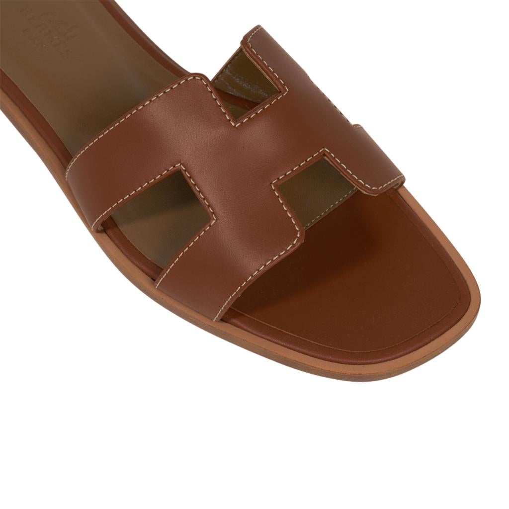 Mightychic offers a pair of Hermes Oran exquisite Gold box calfskin slide.
The iconic top stitched H cutout over the top of the foot in sublime calfskin.
Gold embossed calfskin insole. 
Wood heel with leather sole. 
Comes with sleepers, signature