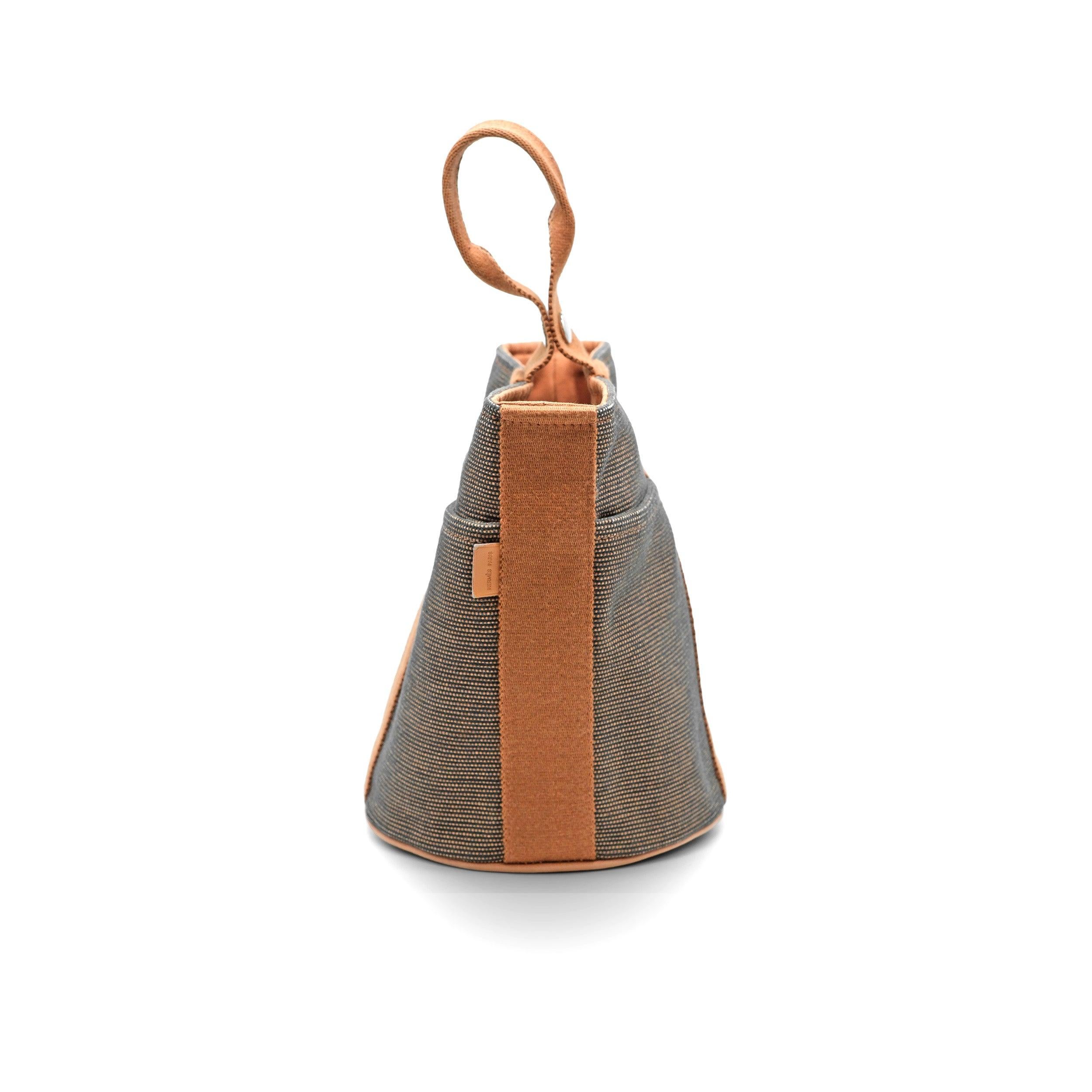 Hermès Saxo PM Bucket Bag in Beige cotton canvas with brown trim. Palladium-plated hardware with snap button top closure. Tone-on-tone canvas lining with inside zip pocket. 
 Material: Canvas 
 Measurement:Height:22;Width:17;Depth:17