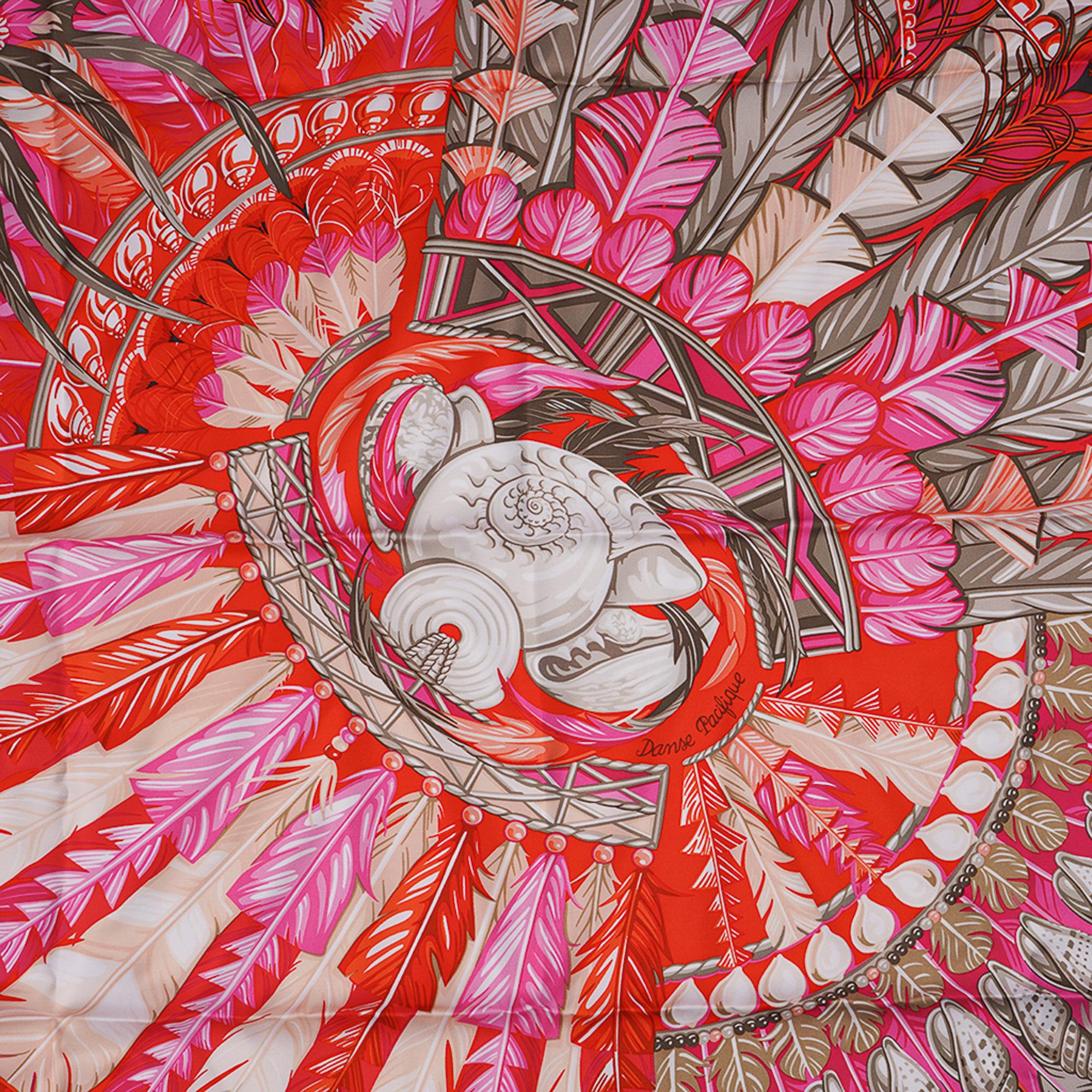 Mightychic offers a guaranteed authentic Hermes Danse Pacifique Silk scarf by Laurence Bourthoumieux.
Pays tribute to the culture of New Guinea.
Features the feather and cowry adorned headdresses of the Pacific.
Orange and Rose Vif
