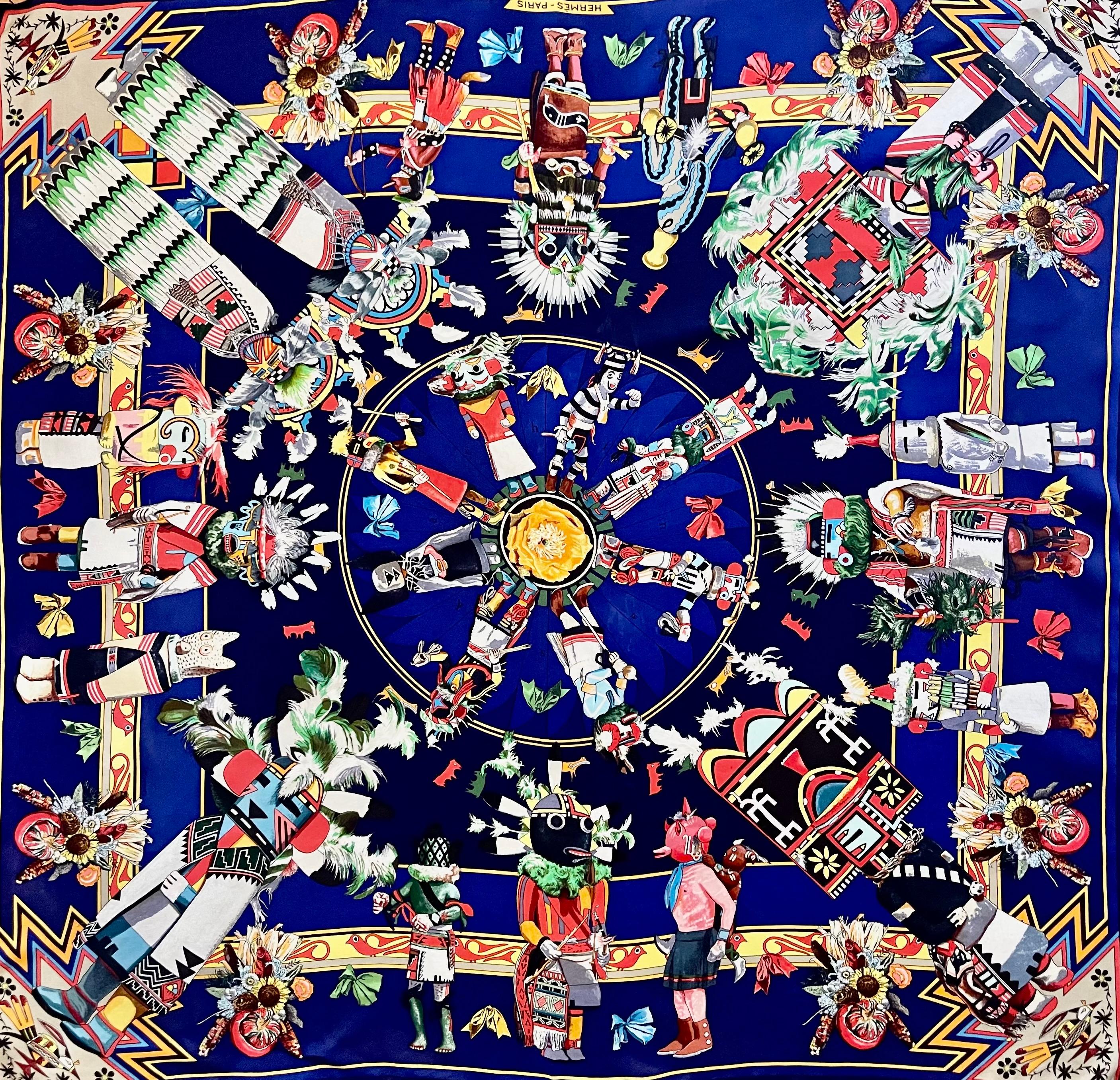 Il foulard Hermès Kachinas, realizzato dall'artista americano Kermit Oliver nel 1992, è un oggetto emblematico che rende omaggio alla cultura delle popolazioni autoctone del sud-est degli Stati Uniti.
In buone condizioni. 
35in x 35in. 