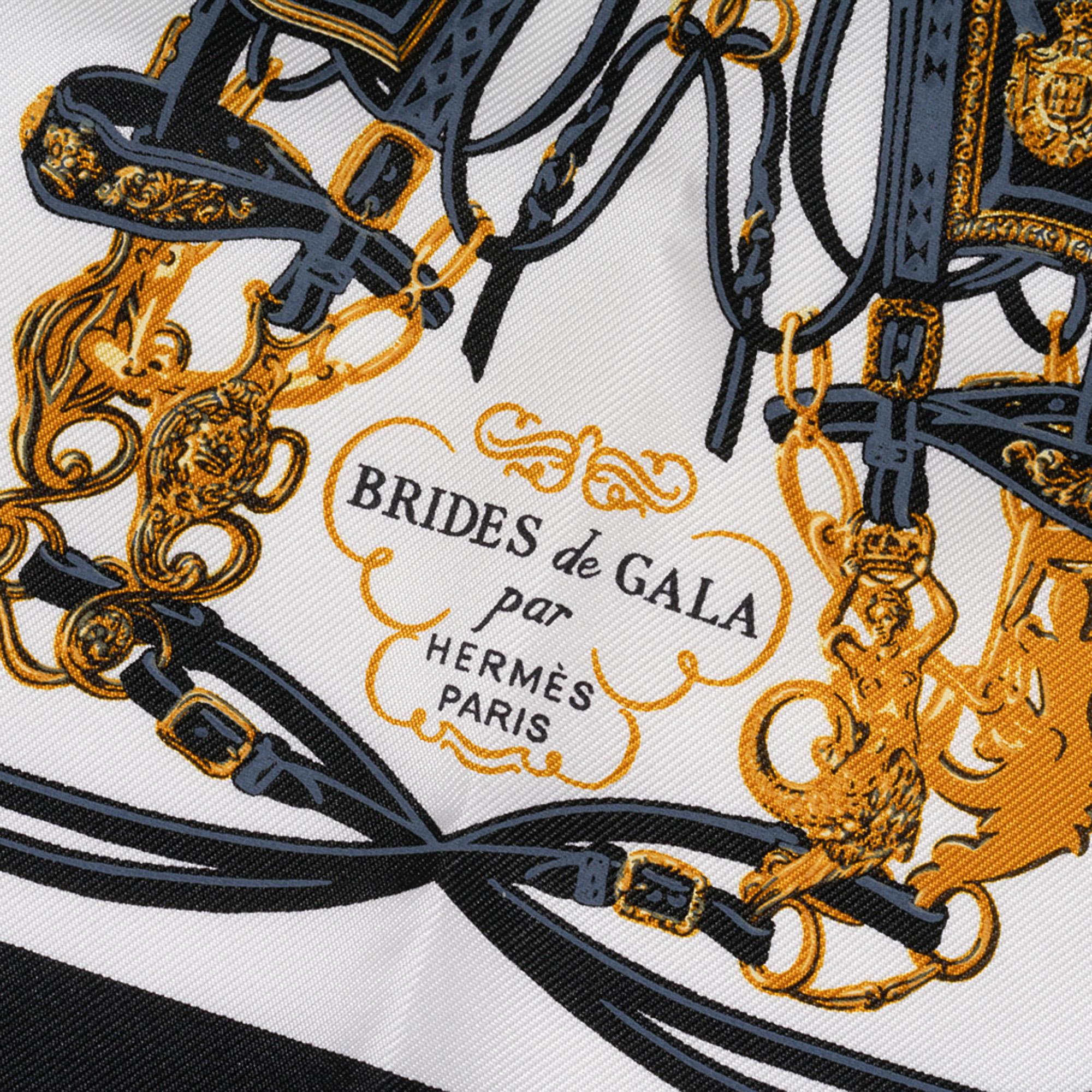 Guaranteed authentic Hermes Brides de Gala 20 cm Nano Scarf featured in Noir, Blanc, Or.
This iconic Hermes scarf can be worn in a myriad ways to add a playful touch to your wardrobe.
Tucked in a pocket, worn on the wrist or ankle, tied to the