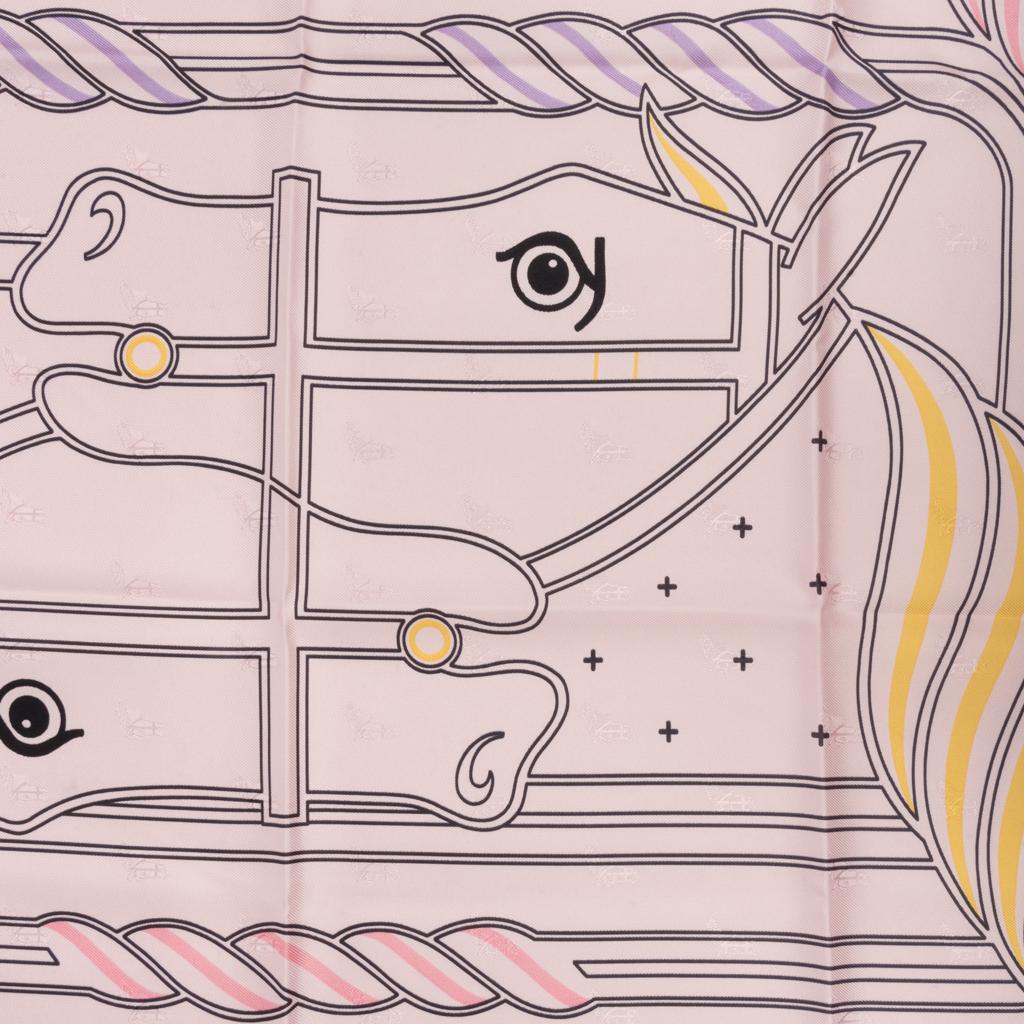 Guaranteed authentic Hermes Quadrige Au Fil Silk Twill scarf designed by Pierre Peron.  
Equestrian Motif - A modern take on the 2-wheel, 4 horse chariot, hence the 4 horse heads.
Exquisite in soft pink Rose Poudre with touches of Jaune and Rose