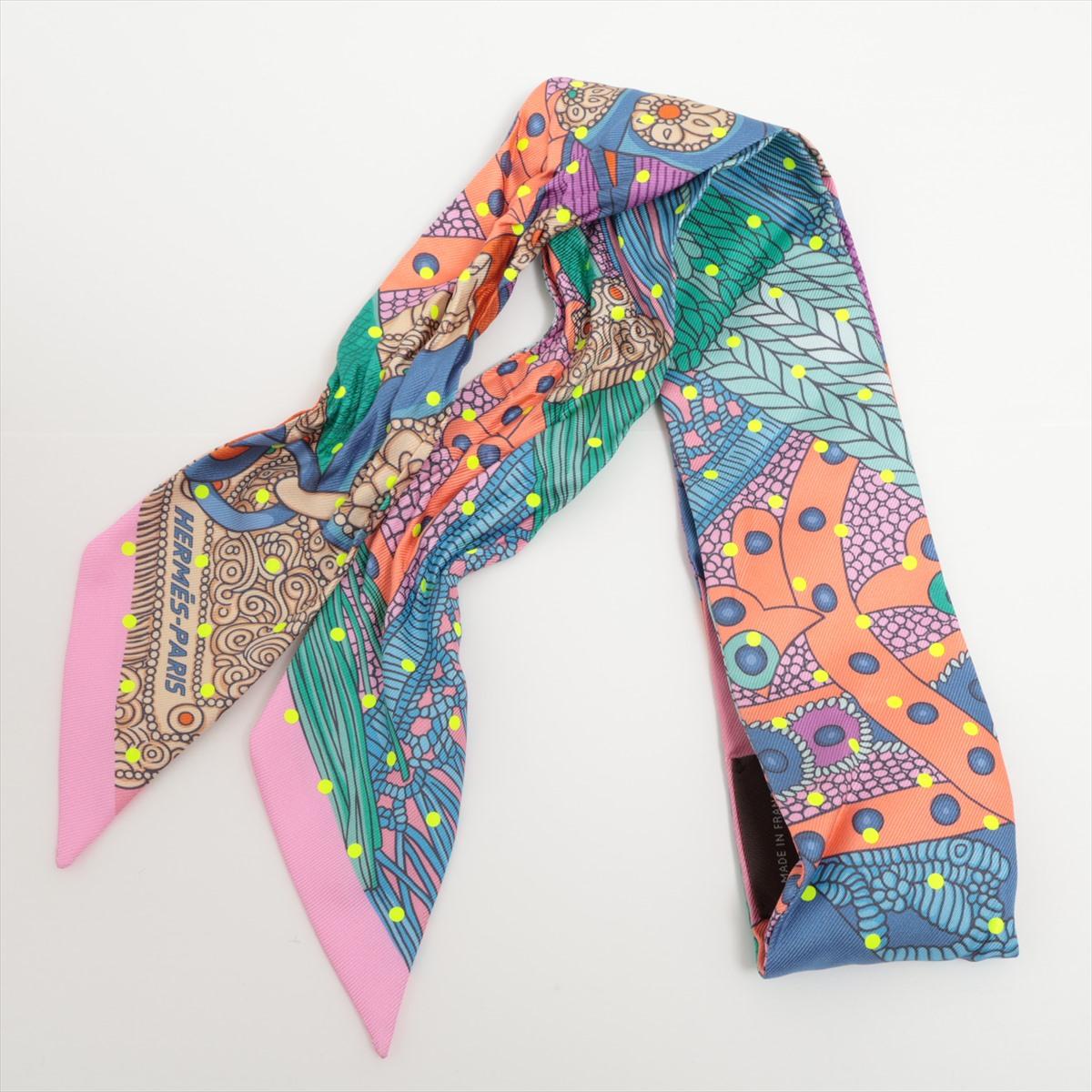 The Hermès Selle de Dignitaire Plumetis Twilly is a delightful and versatile accessory that adds a touch of elegance to any outfit. Crafted from luxurious silk twill, the Twilly scarf features a charming Selle de Dignitaire design, showcasing