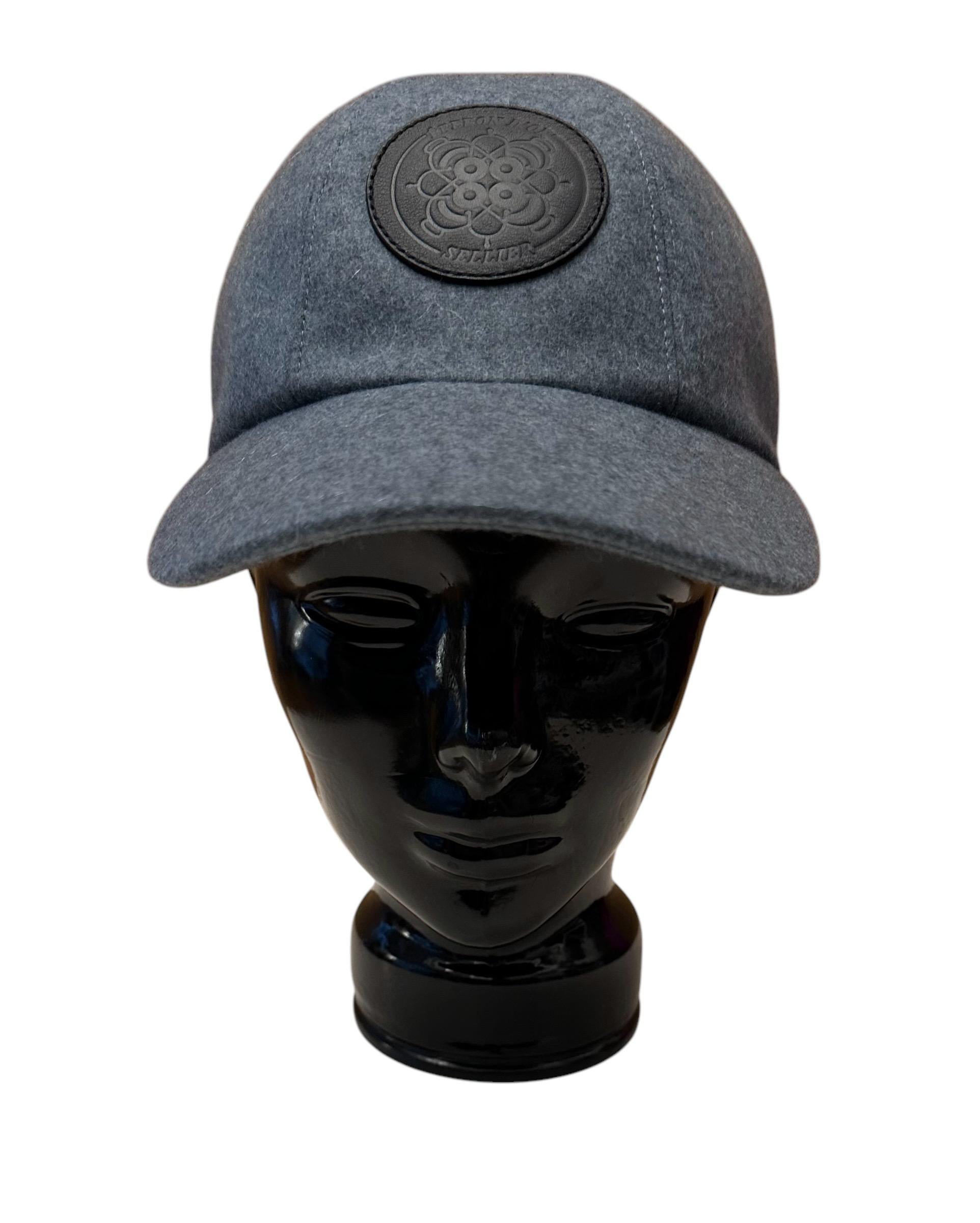 This pre-owned Hermès cap is a classic and a must ! 
It is made of blue grey tone water-repellent cashmere cloth and features an Eperon d'Or embossed leather badge in the front.
A snap closure at the back with 2x 