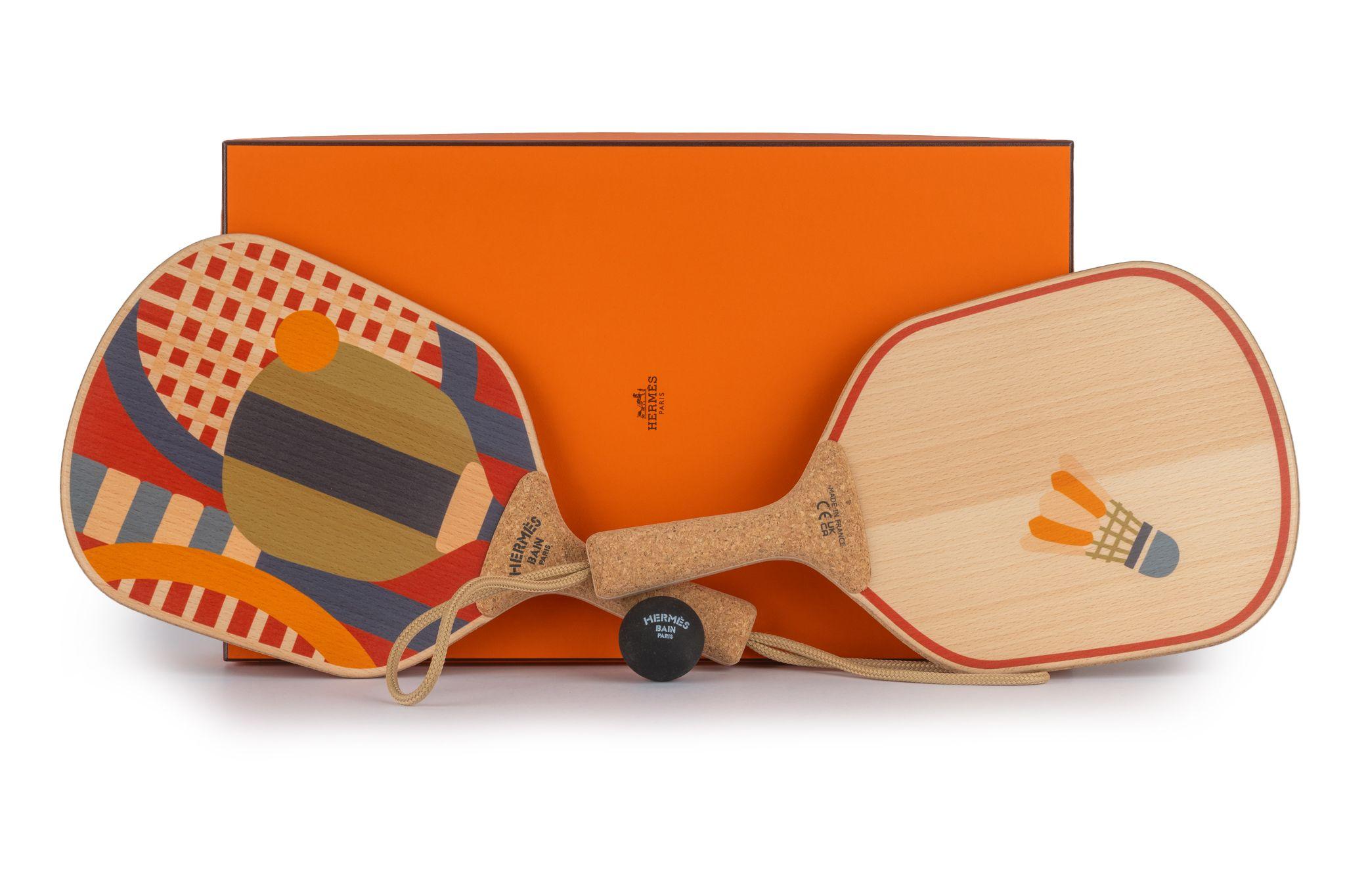 Hermès brand new in box set of 2 beach rackets in printed beechwood and cork, rubber ball, dust cover and box included.