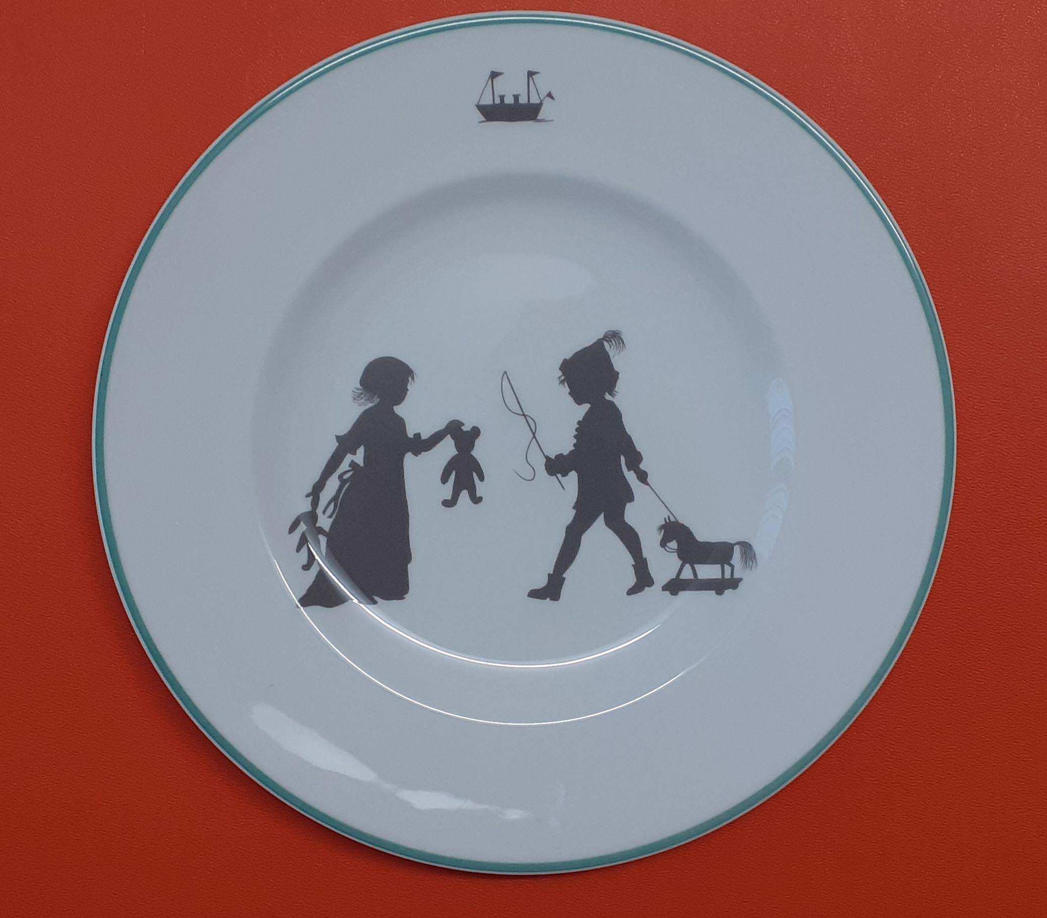 Super Cute Set of 2 Authentic Hermès Plates

From the “SILHOUETTES” collection

Depicting a little girl with a stroller and a cat and a mouse on top, and 2 children with teddy bears and horse on wheels, boat on top

Made of Porcelain Fine Bone China
