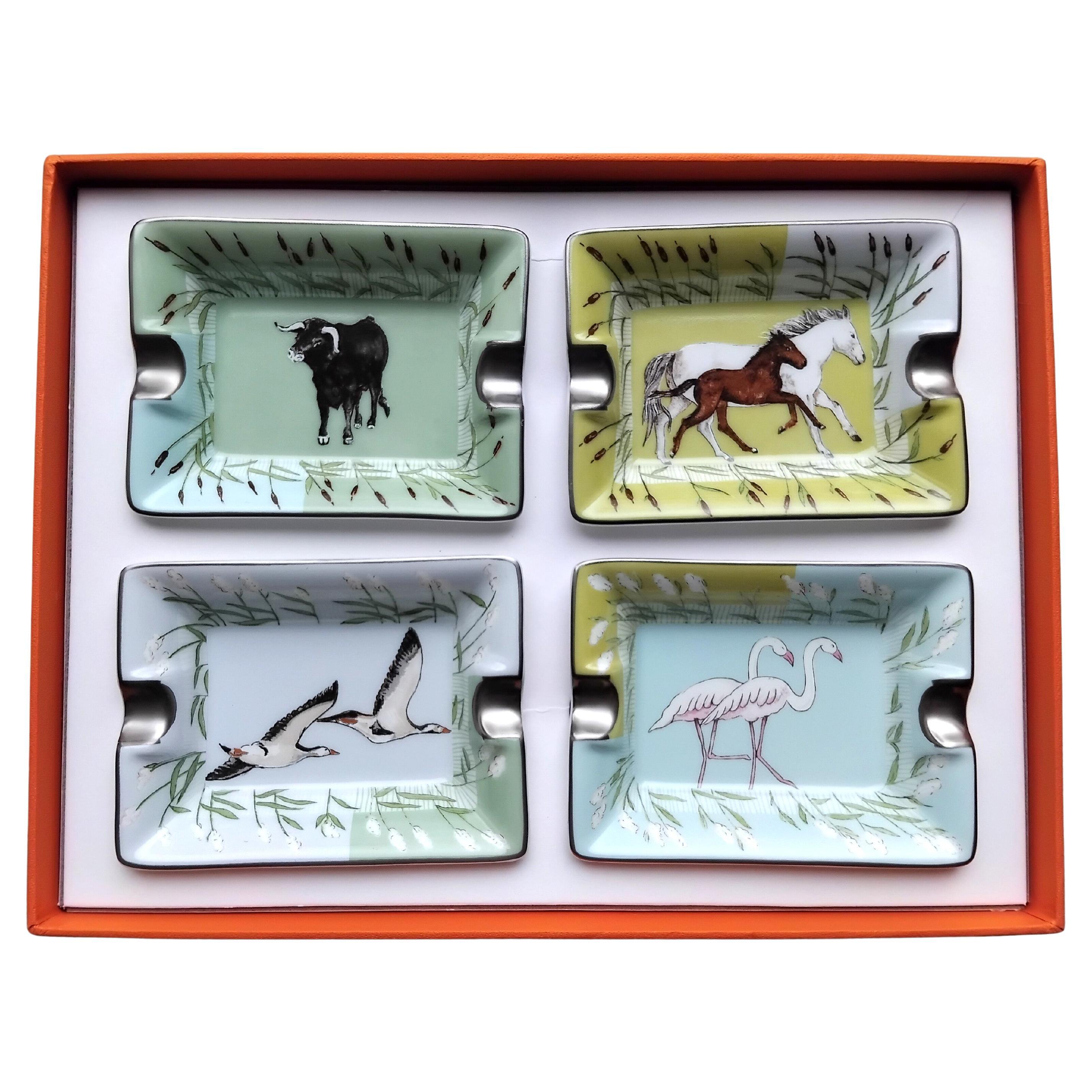 Raro set di 4 mini posacenere Hermès 

Stampe: Toro, cavalli, fenicotteri rosa e altri uccelli

Disegni ispirati alla fauna della zona francese della Camargue

Chiamati anche 