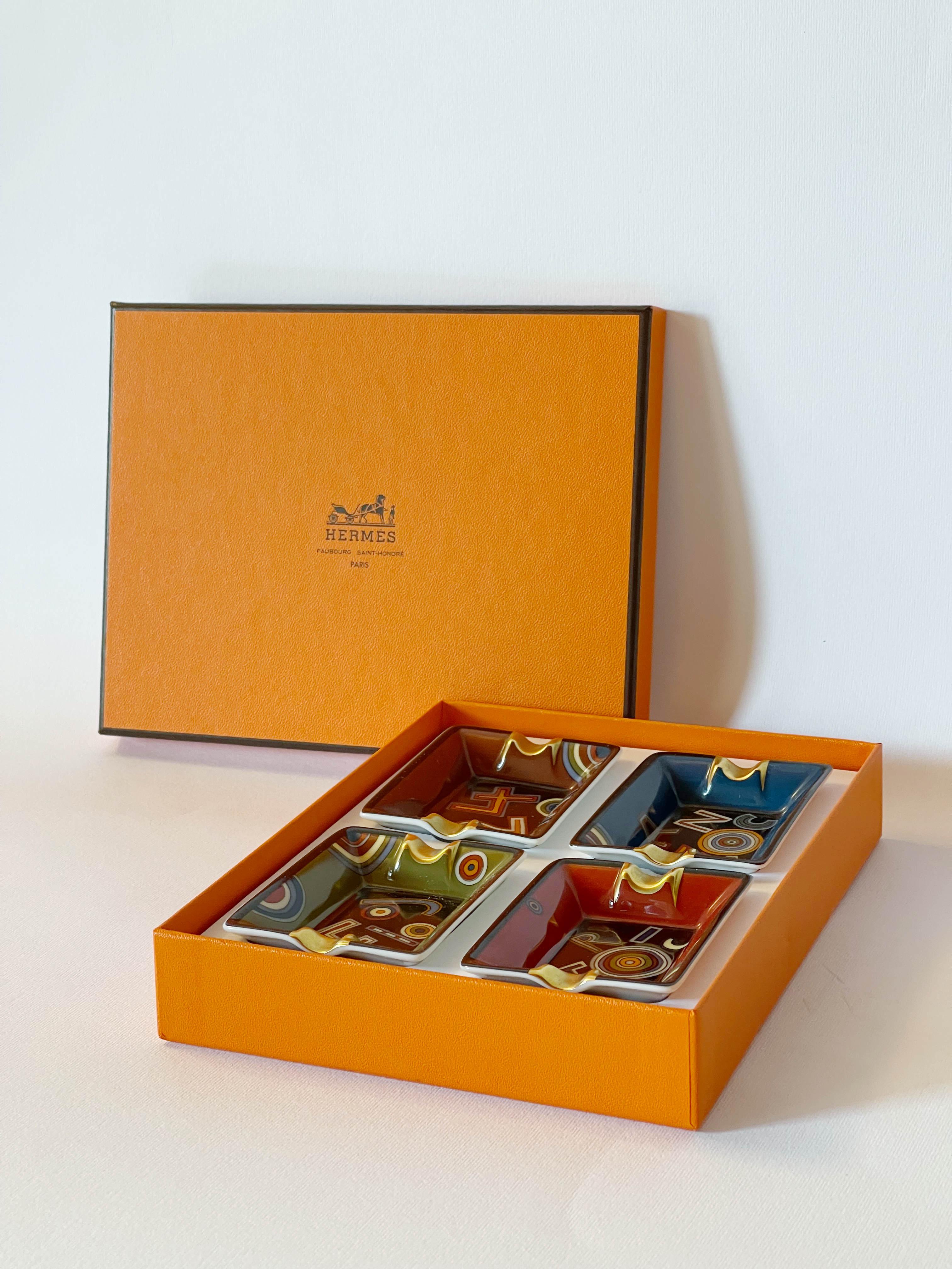 Limited Edition set of 4 Hermes Tohu Bohu multi-color mini porcelain ashtrays, with notches gilded with gold and bases covered with leather / Made in France

Each astray has one of the four words 