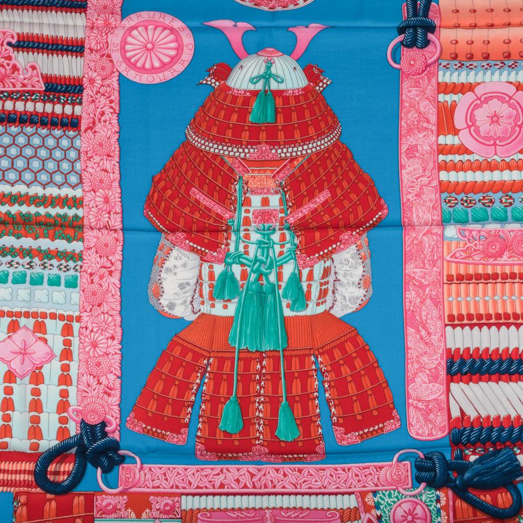Mightychic offers an Hermes Cashmere and Silk 140cm shawl Parures de Samourais. 
Shawl with signature hand rolled orange edge. 
Vivid tones in turquoise, orange, and rose.
Exquisite composition designed by Aline Honore features a suit of armor and