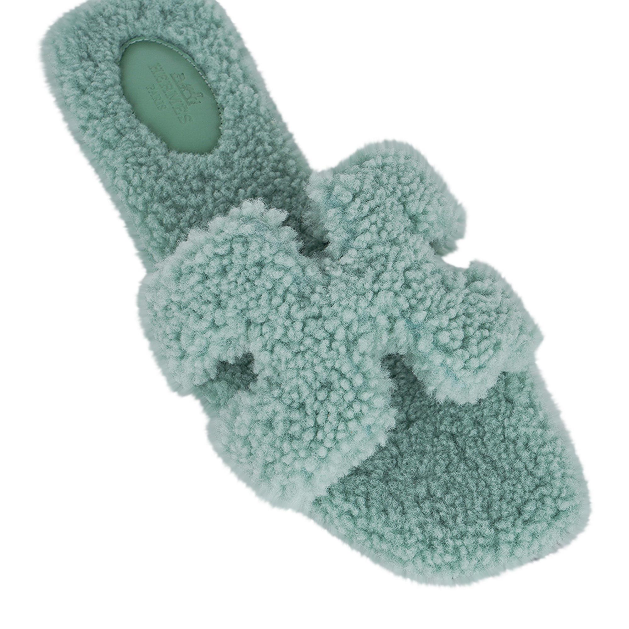 Mightychic offers a pair of Hermes Oran Shearling limited edition flat sandal slide featured in Vert D'Eau.
This stunning pale green Hermes Oran shearling sandal is foot flirting perfection!
Embossed Hermes Paris leather insole.
Wood heel.
Comes