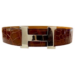 Cintura Hermes in pelle di coccodrillo lucida con fibbia grande H. H.