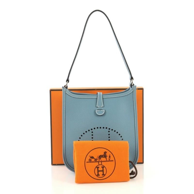 This Hermes Short Strap Evelyne Shoulder Bag Epsom TPM, crafted from Blue Jean blue Epsom leather, features a perforated H design at the front, flat leather strap, and palladium hardware. It opens to a Bleu Jean blue raw leather interior. Date stamp