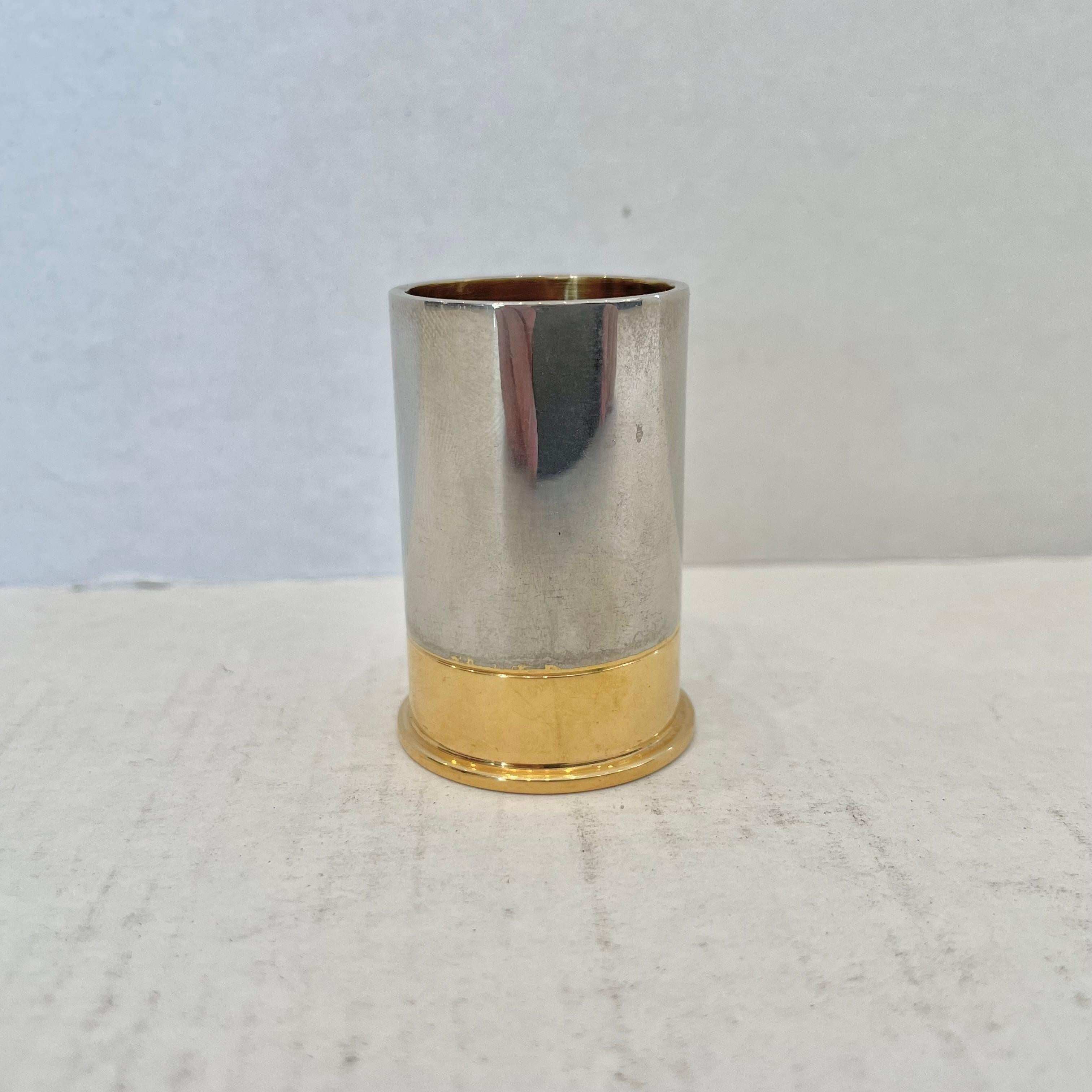 Classic silver cup with brass bottom made by Hermès. In the shape/style of a shotgun shell. Stamped Hermès Made in France on underside of brass. Good vintage condition. Great desktop item with functionality and fun design.
