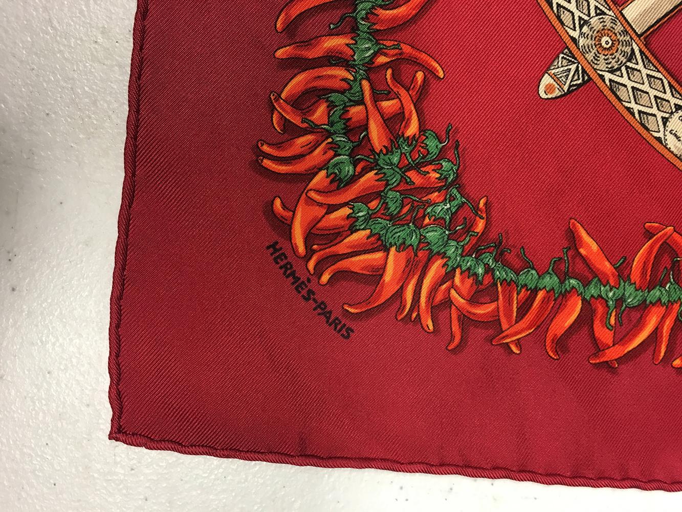 GORGEOUS Hermes Aux Pays des Epices silk pocket square in excellent condition. Original silk screen design c2001 by Annie Faivre features an array of herbs and spices in the center wheel design surrounded by bright chili peppers and a dark red