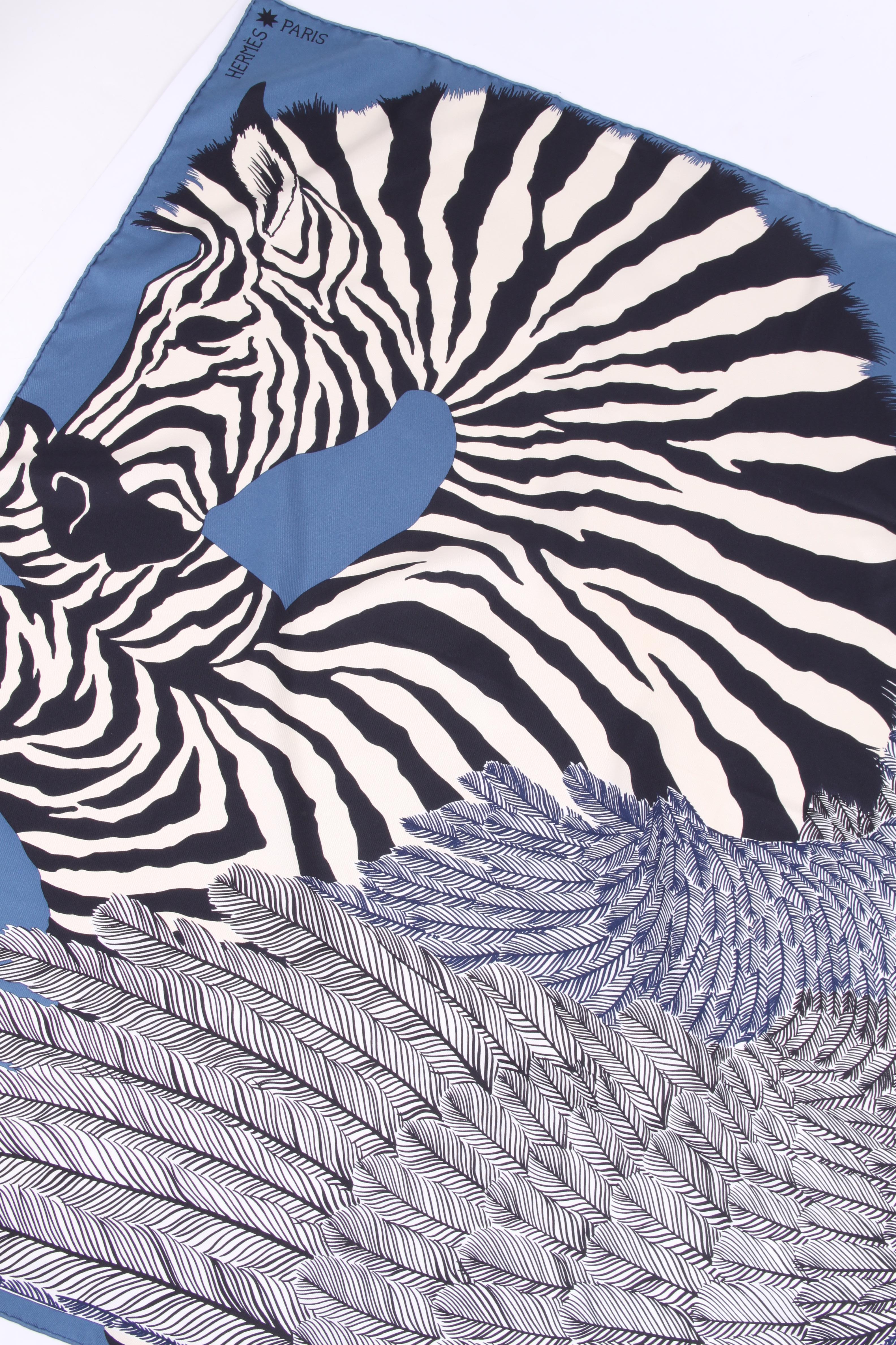 This marvellous silk scarf by Hermes is covered with a zebra print on a blue foundation.

Name: Zebra Pegasus
Measurements: 90 x 90 centimeters
Colors: blue, black, white
Material: silk
Condition: like new (9,5/10)

Made in France.