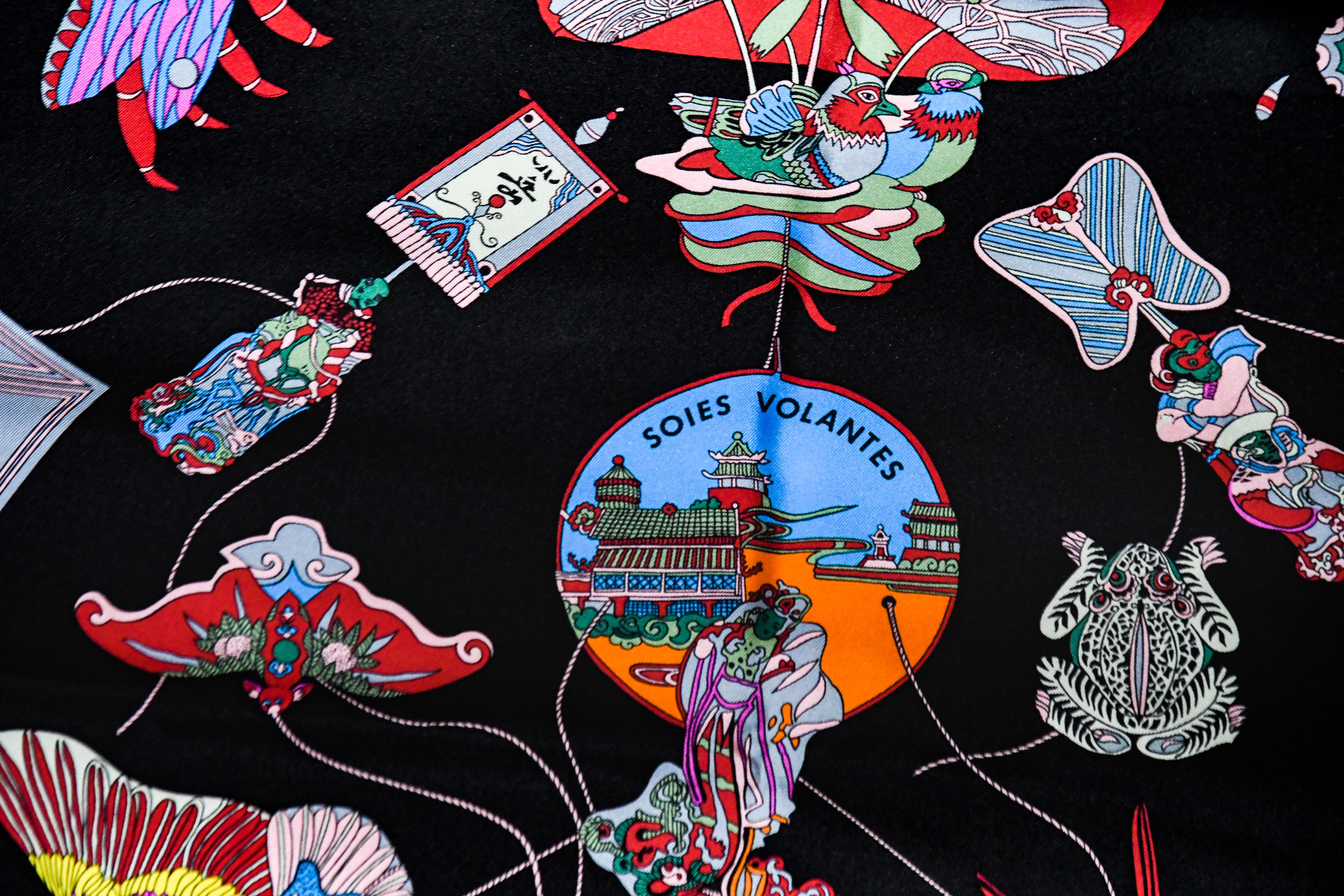 This silk scarf has amazingly vivid colors of decorative Chinese kites against a black background  framed in orange and yellow trim.  This Chinese kites theme silk scarf depicts a variety of butterflies, birds and chinese motif decorations.  This