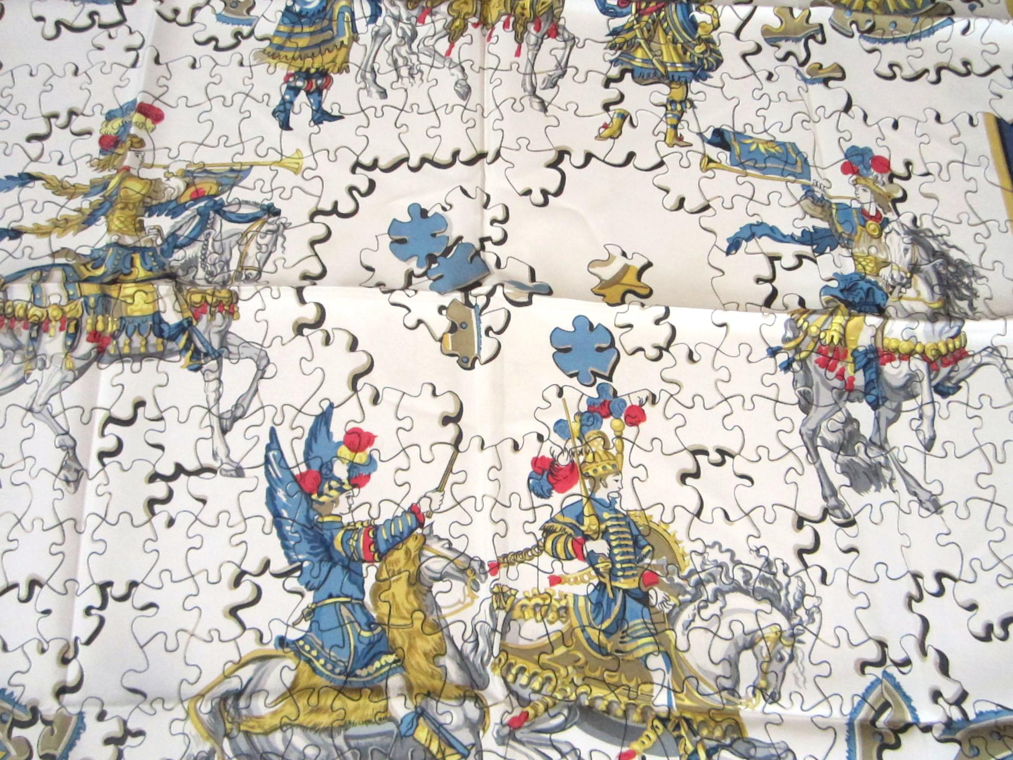 Hermes puzzle scarf Designed by Francoise Heron in 1971. Blueish border with greys, reds and cream. Lightly used, still has the box.   Please be sure to check our storefront for more Hermes, Gucci, and Escada scarves of which 95% are new never worn!