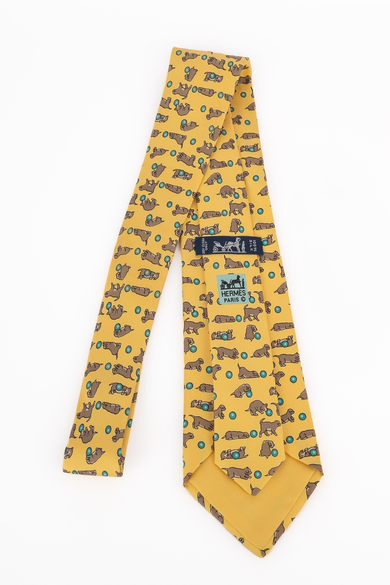 HERMÈS - (Made in France) Yellow silk tie printed with tiny dogs playing with a ball.

Condition:
Very good condition

Dimensions:
Max. width: 9 cm

SKU:ACC37