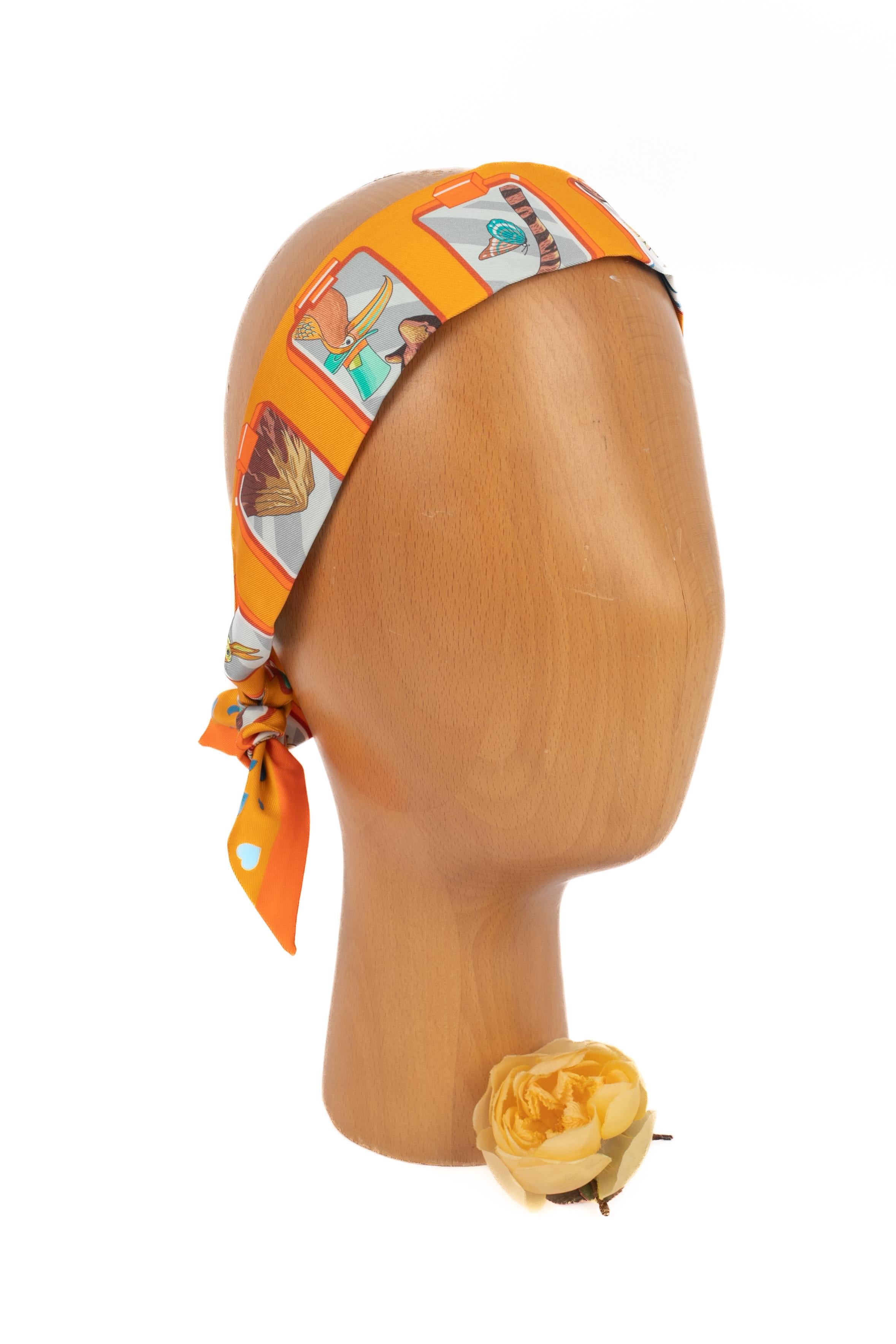 HERMÈS - (Fabriqué en France) Twilly en twill de soie orange.

Condit :
Très bon état.

Dimensions :
Longueur : 85 cm - Largeur : 5 cm

SKU:FFH2