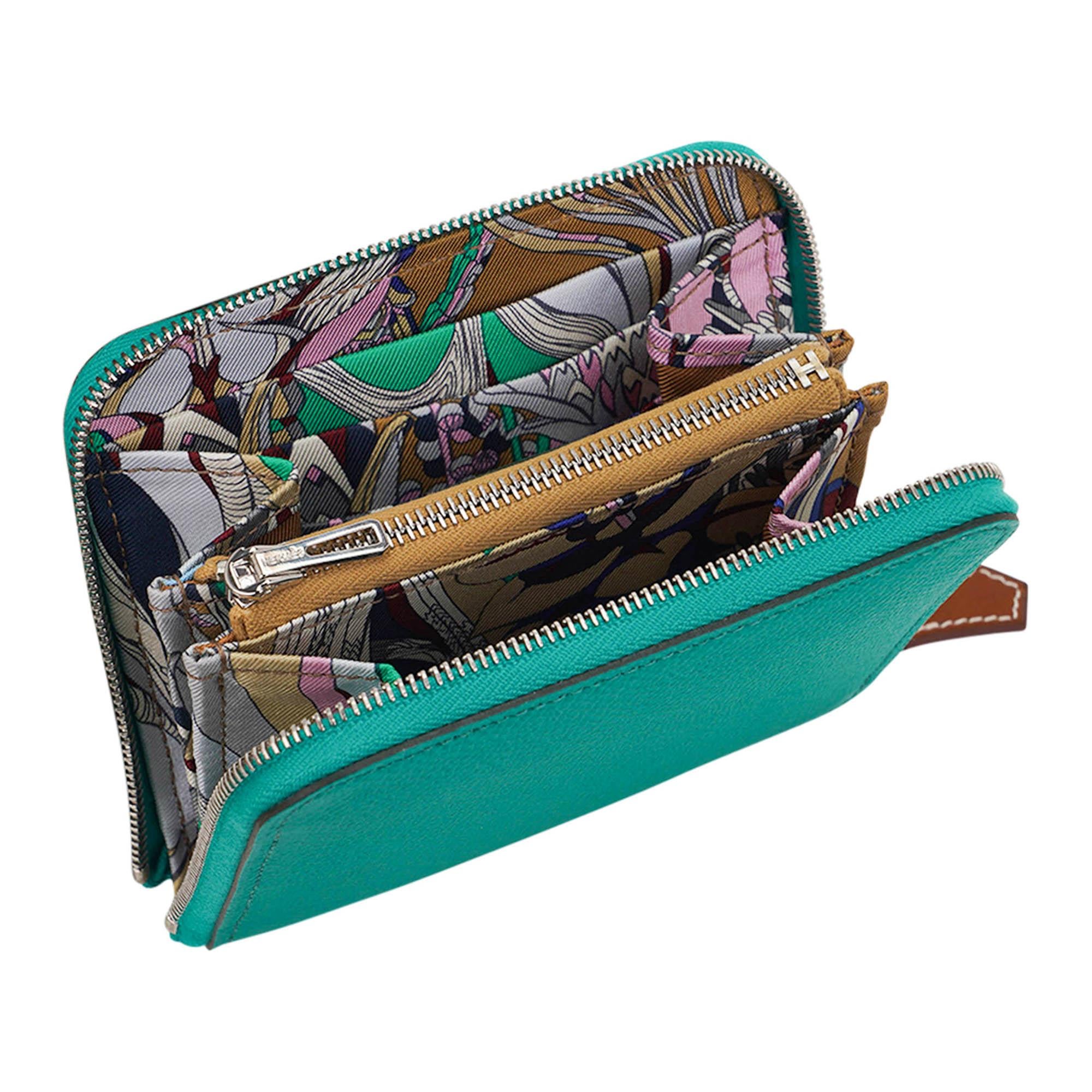 Mightychic offers an Hermes Silk'In Compact Wallet featured in jewel toned Jade.
Interior is lined in silk twill Botanical Fantasy print by Virginie Jamin.
This beautiful coin wallet has 3 credit card slots on each side with center zip