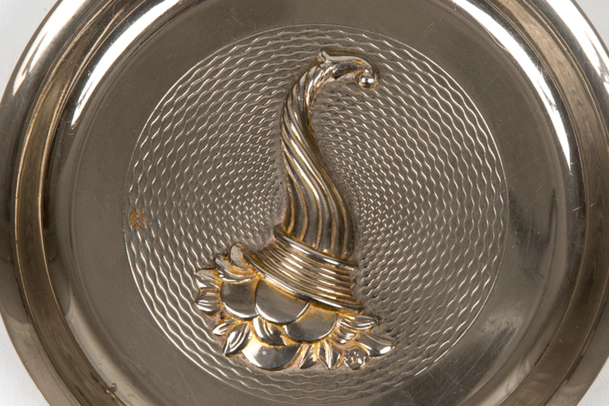 Hermès Silber dekorative Veranstalter mit einem Füllhorn, Corne d'Abondance in seiner Mitte, eine runde Form, zurück entsteint Leder Hermes Signatur auf der Rückseite fehlt. 
Circa 1970er Jahre 
In gutem Vintage-Zustand. 
Durchmesser: 4,7 Zoll (12