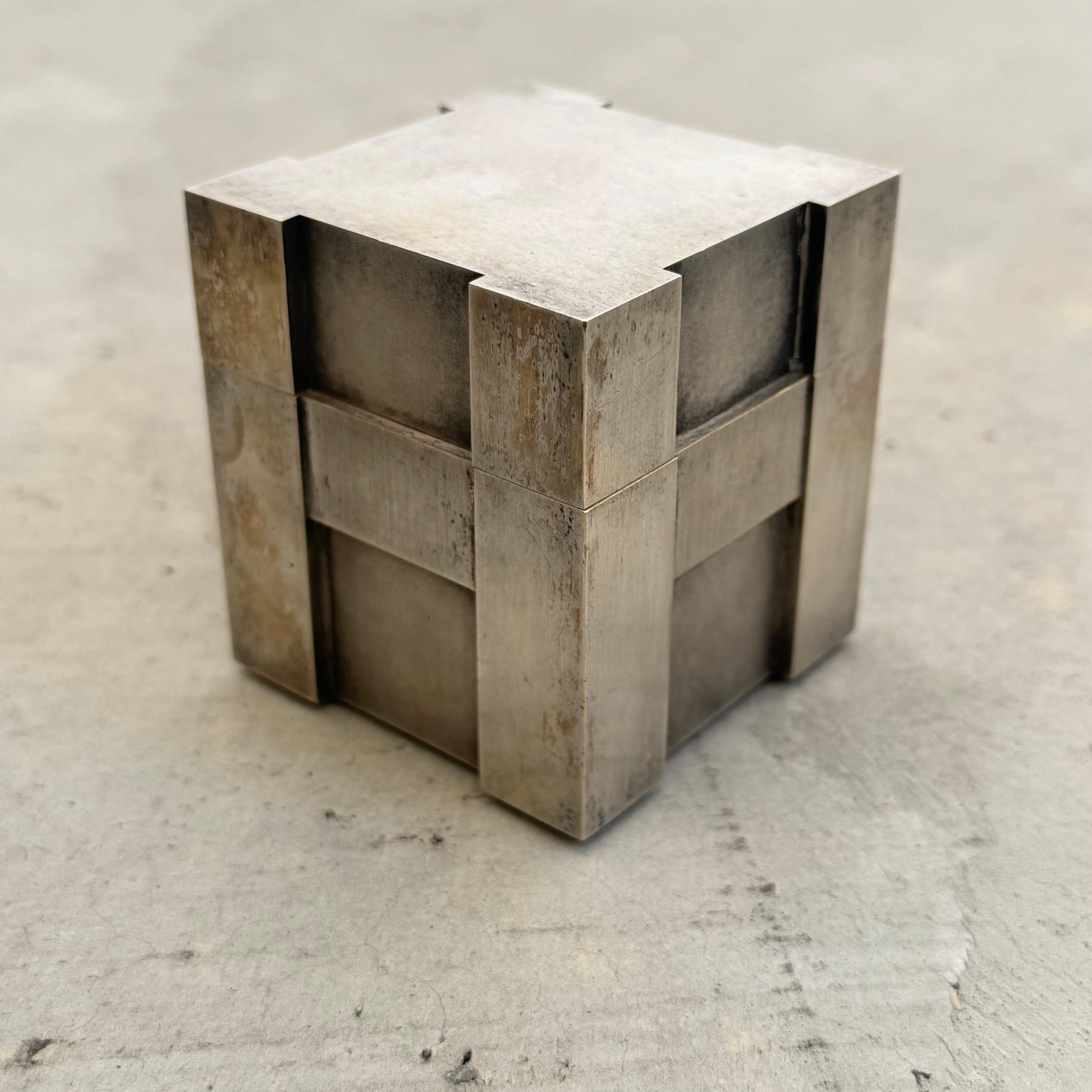 Magnificent cube lighter by Hermes, Paris. In cast metal with silver plating, this piece is meticulously handcrafted. The letter 'H' emerges from the structural silhouettes, echoing seamlessly along four sides. With incredible patina, this lighter