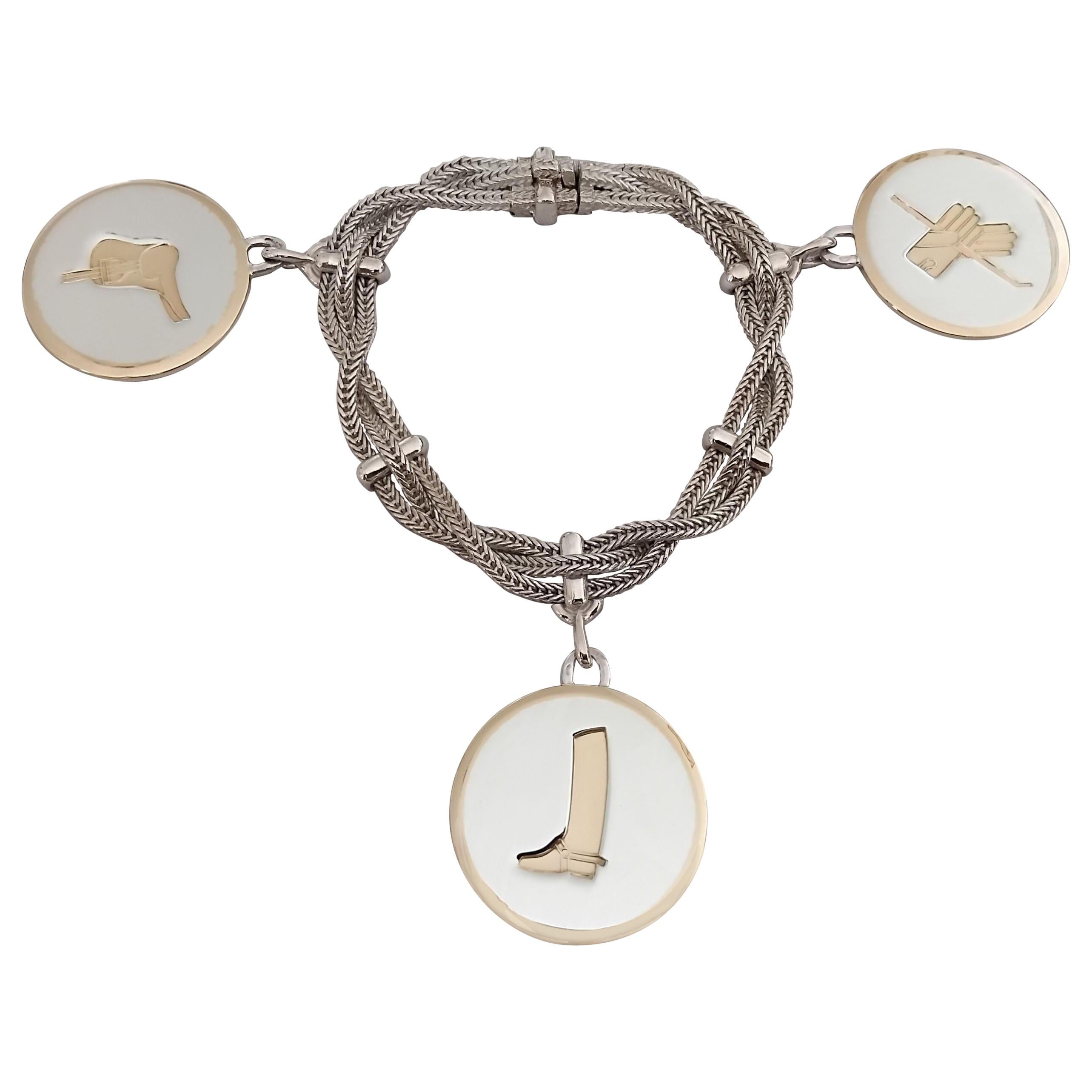 Eccezionale Bracciale autentico di Hermès

Questo braccialetto è tra i più rari e più belli

3 catene intrecciate, impreziosite da 3 charme incisi con disegni a tema equestre: stivale da equitazione, sella e guanti da equitazione con frusta

La