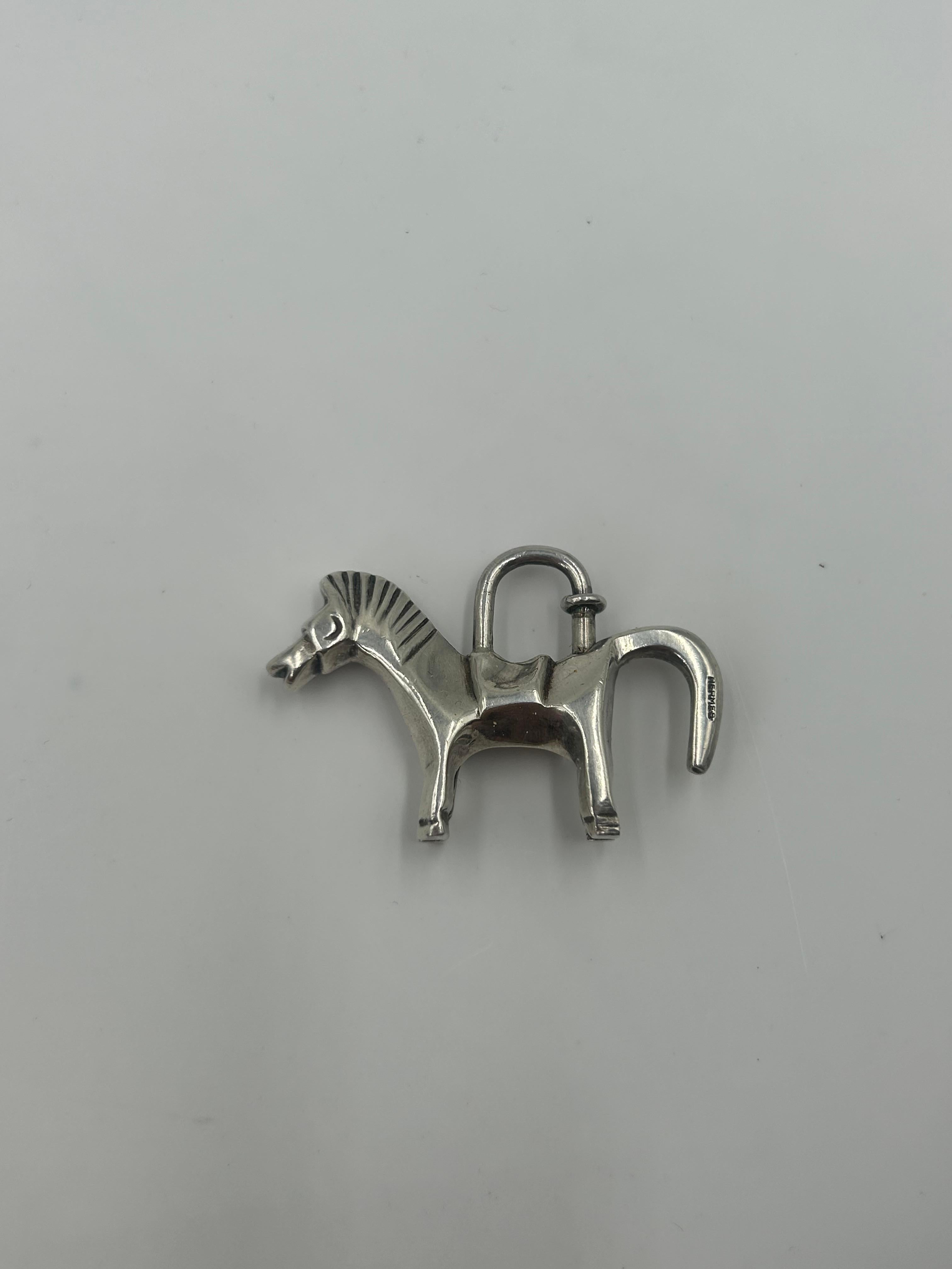 This Hermès lock is a classic polished metal padlock, instantly recognizable as a signature hardware detail of the brand’s most coveted handbags. Crafted in silver, the lock is engraved with “Hermès – Paris”.  Elegant and utilitarian, it serves both