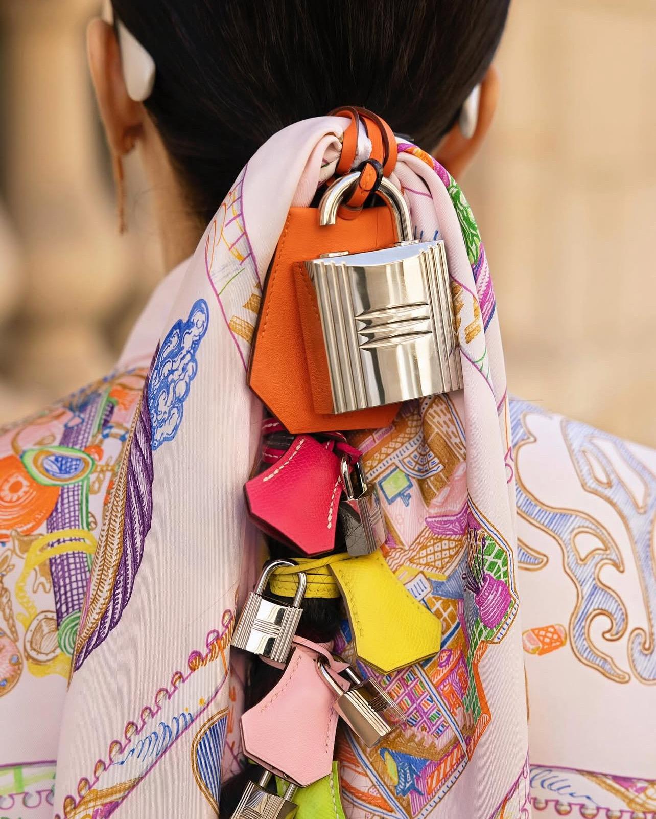 The Hermes Silver-Tone Padlock Fragrance Spray Holder is a chic and versatile accessory that combines functionality with sophisticated style. Crafted in a sleek silver-tone finish, this padlock-inspired piece features an open design that allows you