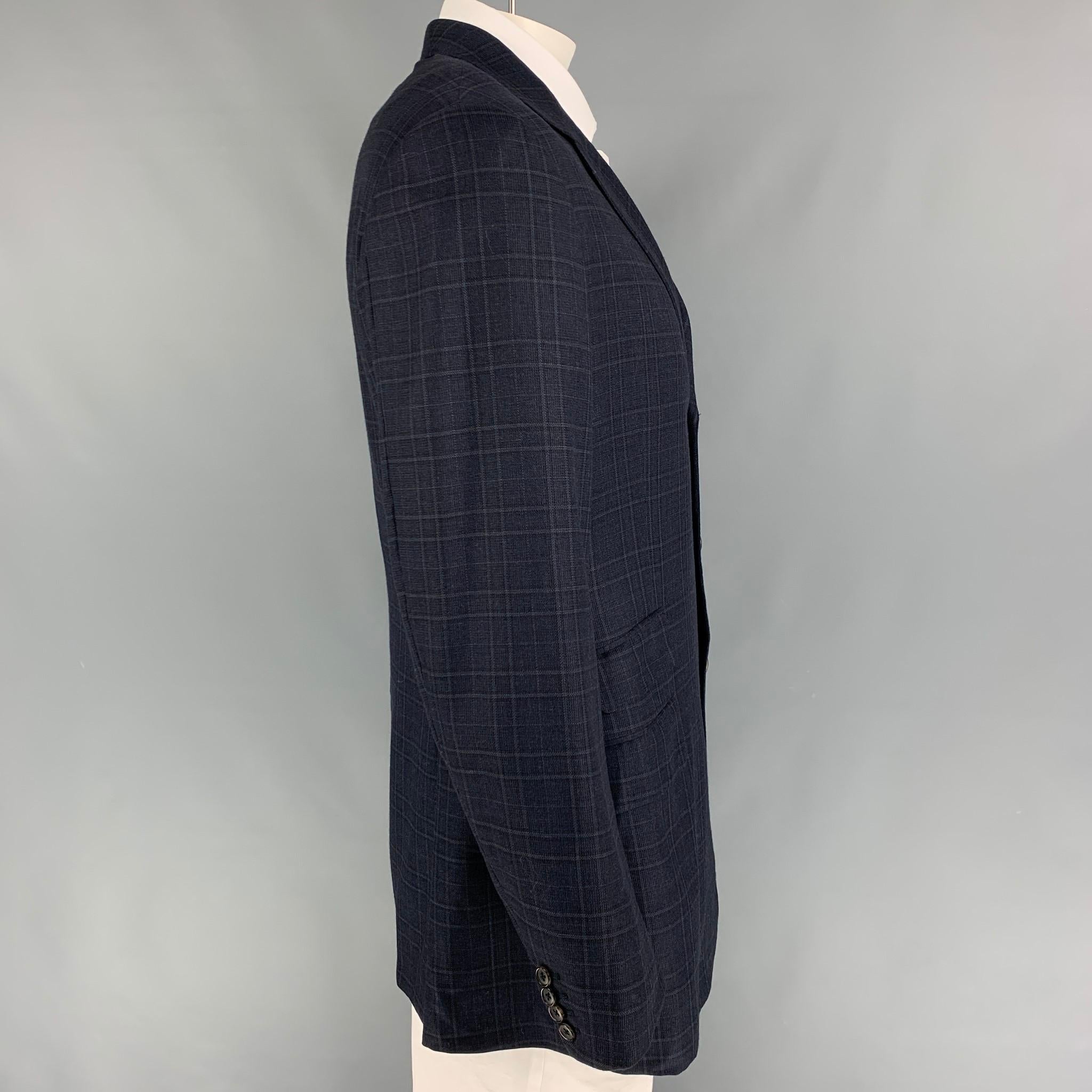 HERMES sport coat comes in a navy & grey plaid wool with a full liner featuring a notch lapel, flap pockets, double back vent, and a three button closure. Made in Italy. 

Very Good Pre-Owned Condition.
Marked: 56

Measurements:

Shoulder: 19.5