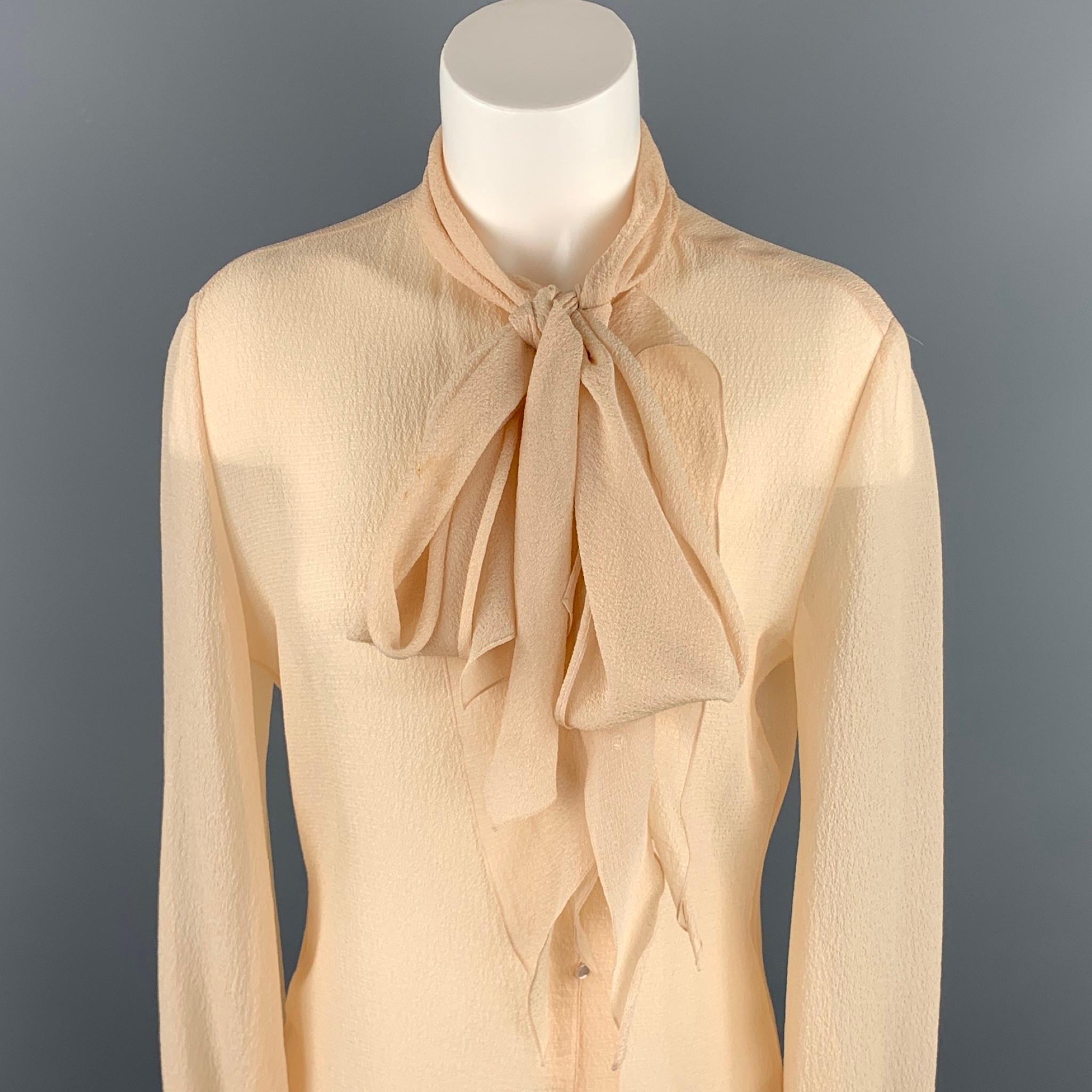 HERMES blouse comes in a beige crepe silk featuring a tie neck design and a buttoned closure. Minor discoloration. As-Is. Made in France.

Good Pre-Owned Condition.
Marked: No size marked

Measurements:

Shoulder: 16.5 in.
Bust: 36 in.
Sleeve: 26